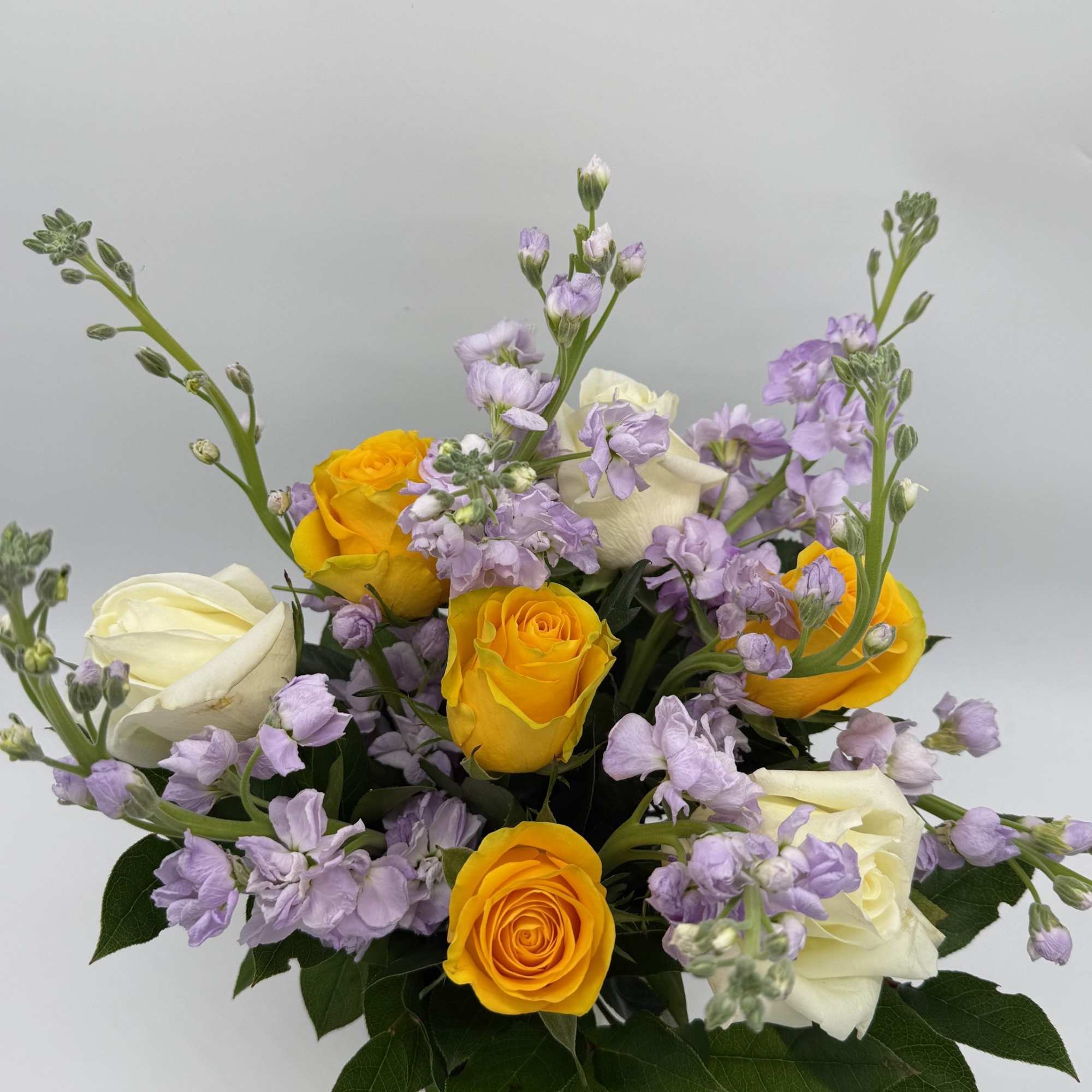 Bouquet of yellow and white roses with light purple flowers