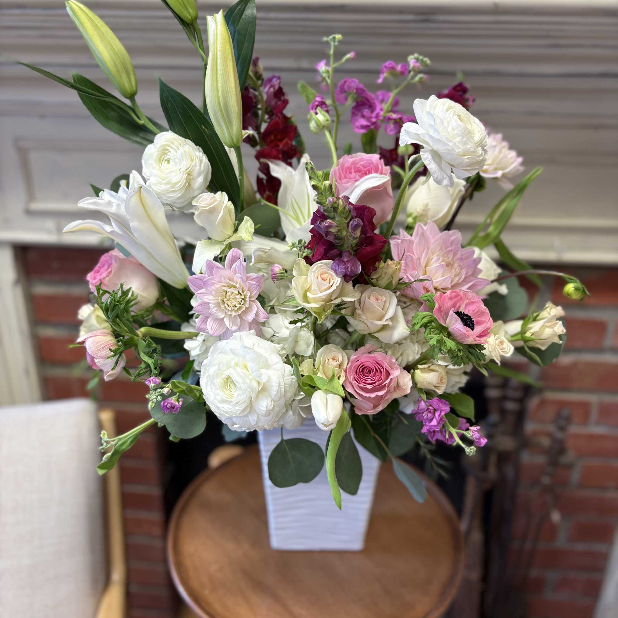 Mixed pink and white flower arrangement in a white vase