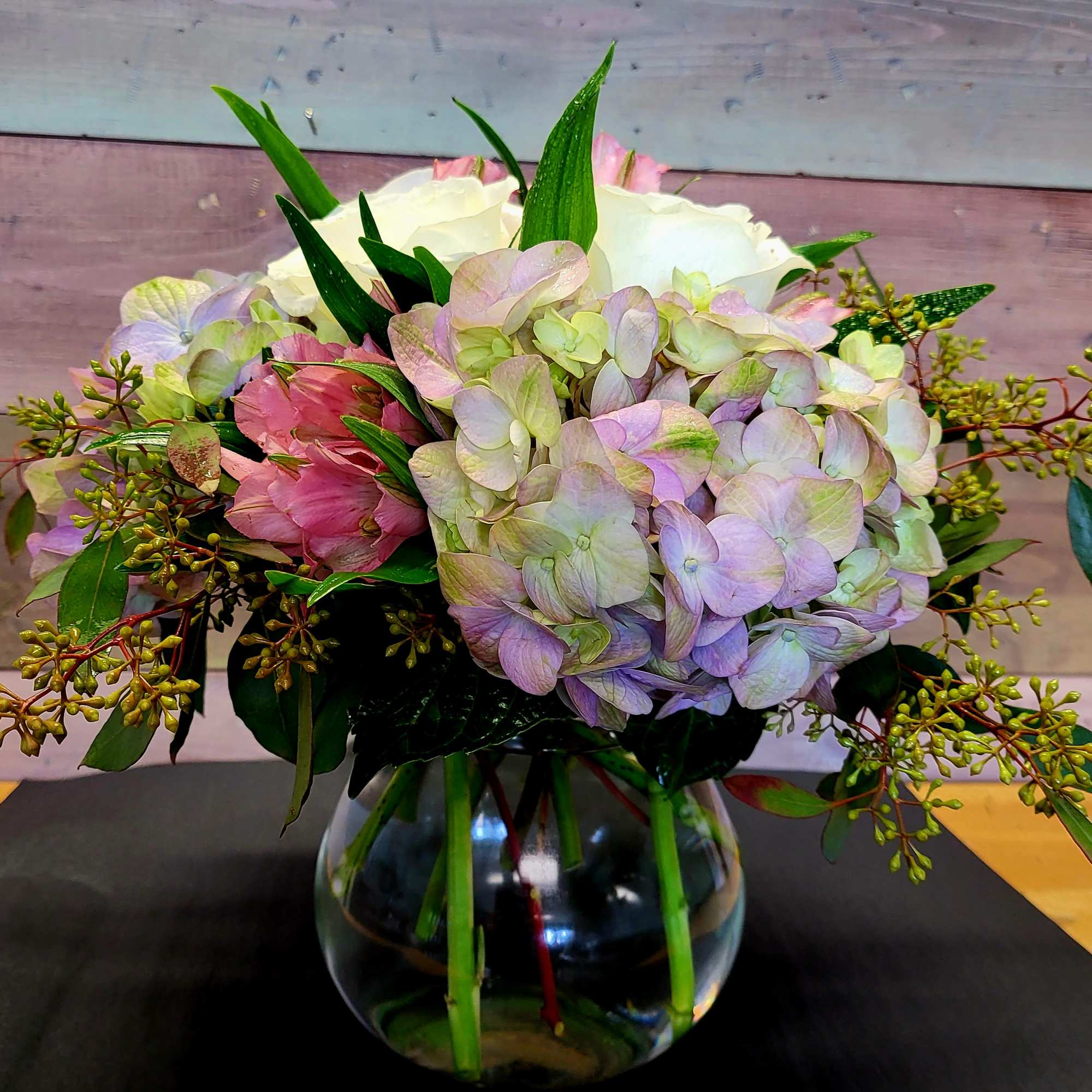 Bouquet of pastel hydrangeas and pink flowers in a glass vase