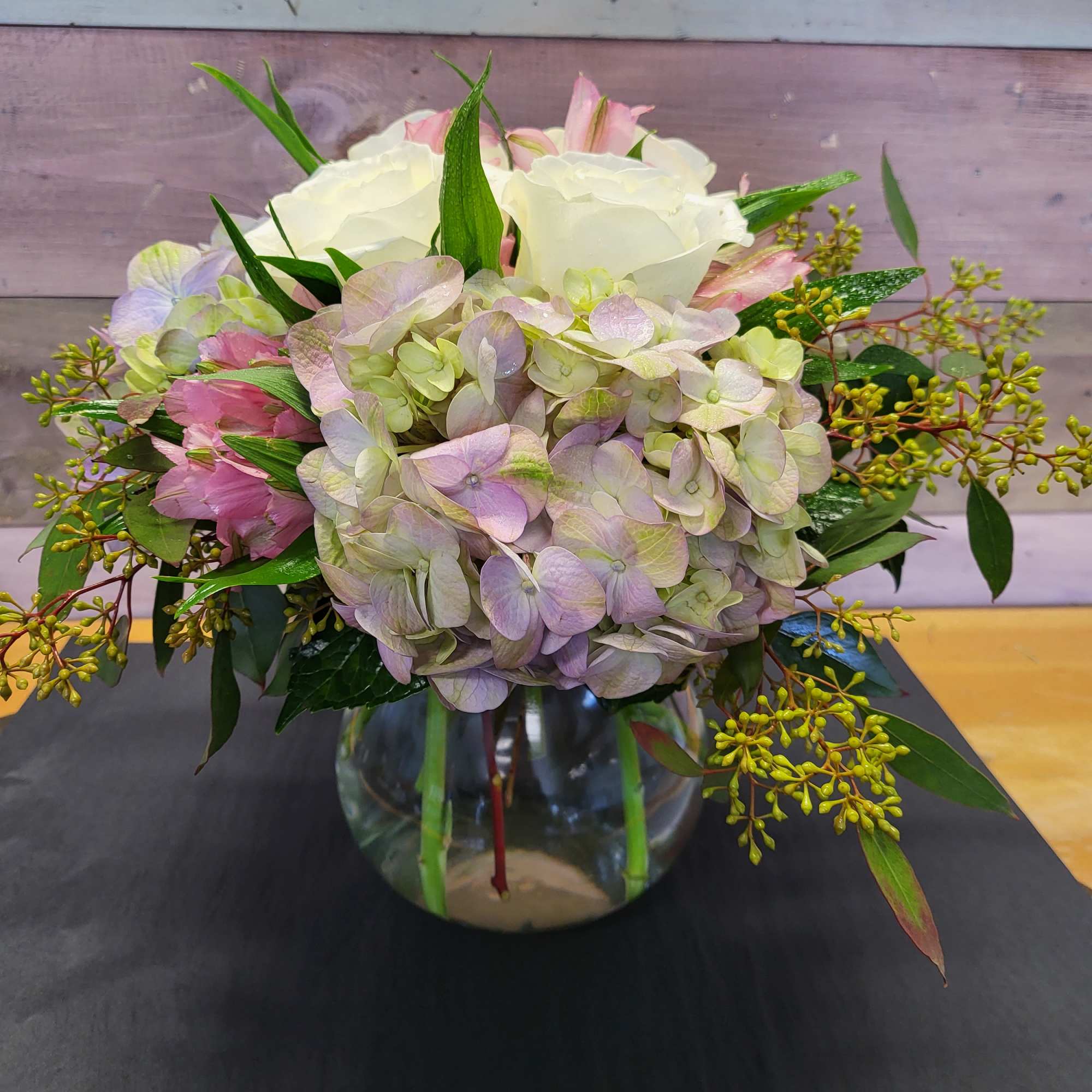 Hydrangea and rose arrangement in a clear glass vase