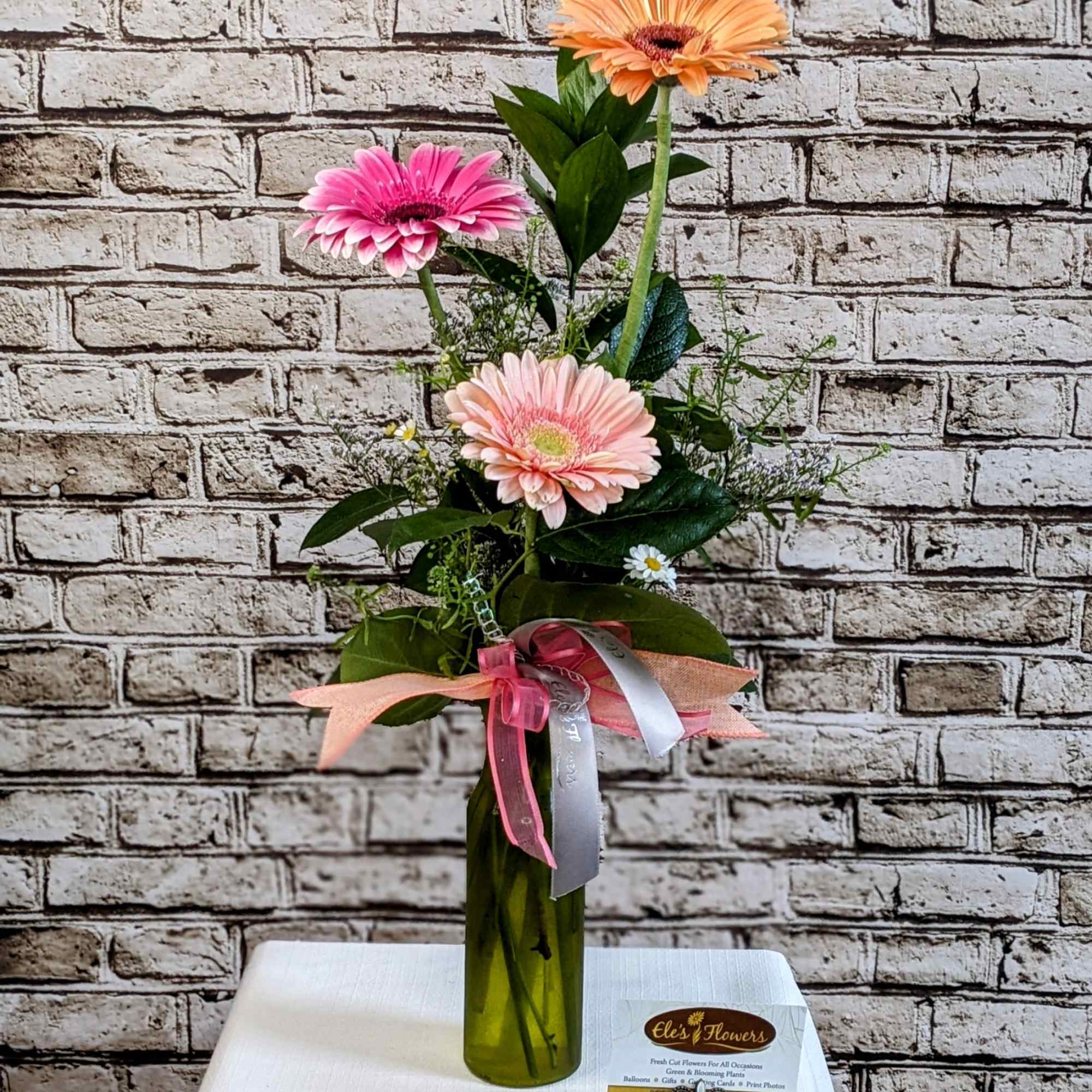 Tall vase arrangement with pink and peach gerbera daisies