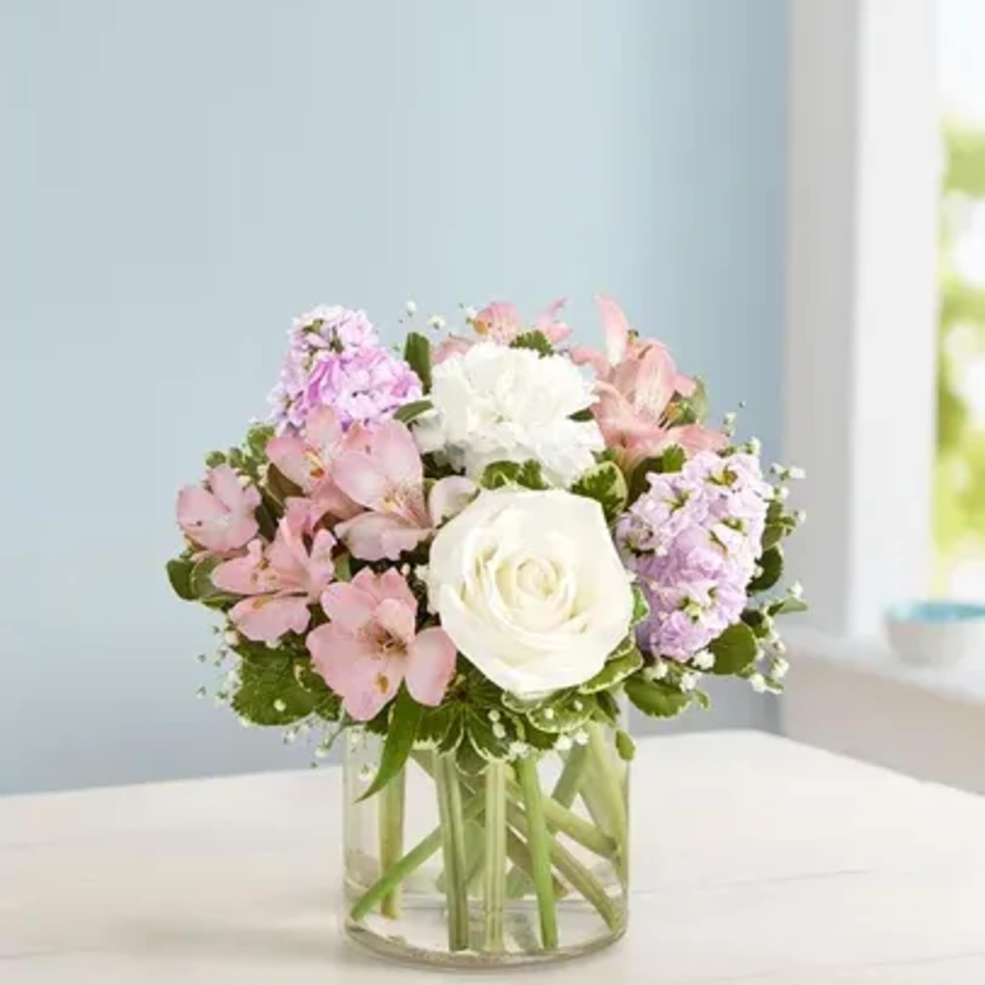 Pink and white flower arrangement in a clear glass vase