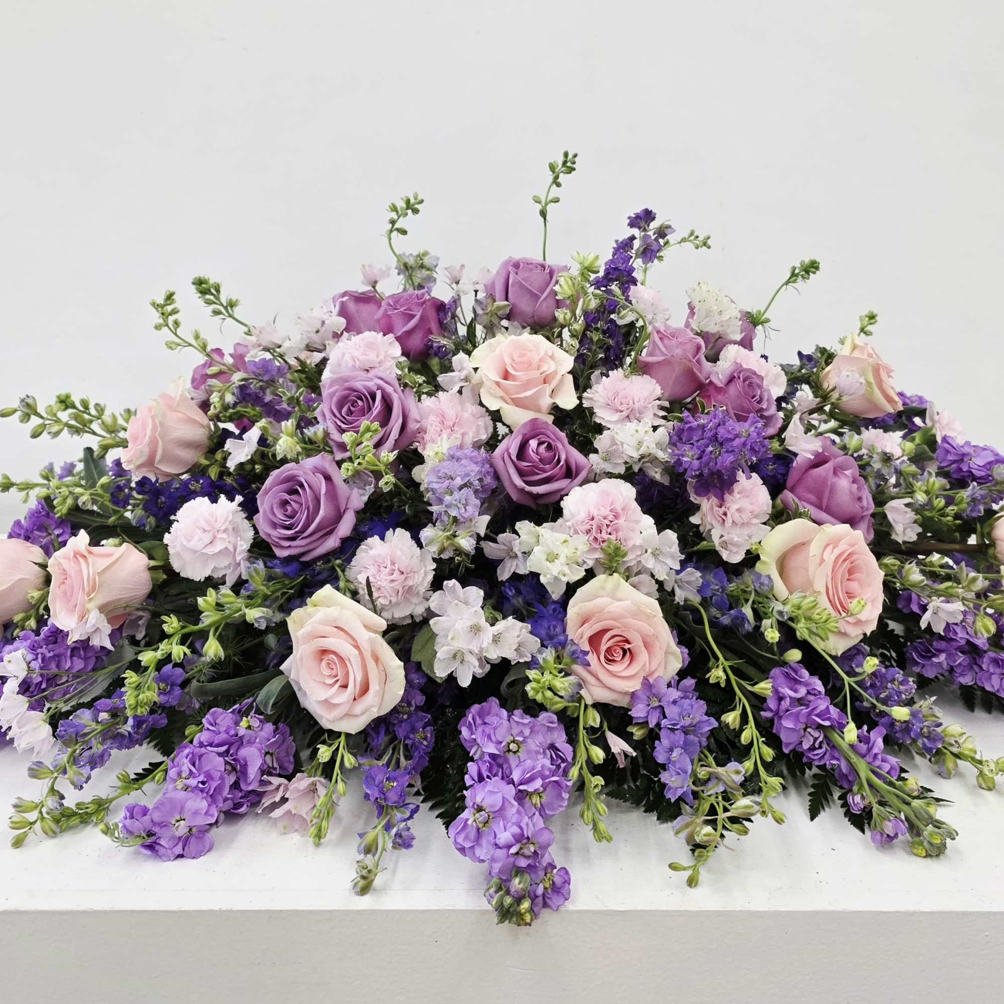 Soft lavender and blush come together in a low, broad floral design