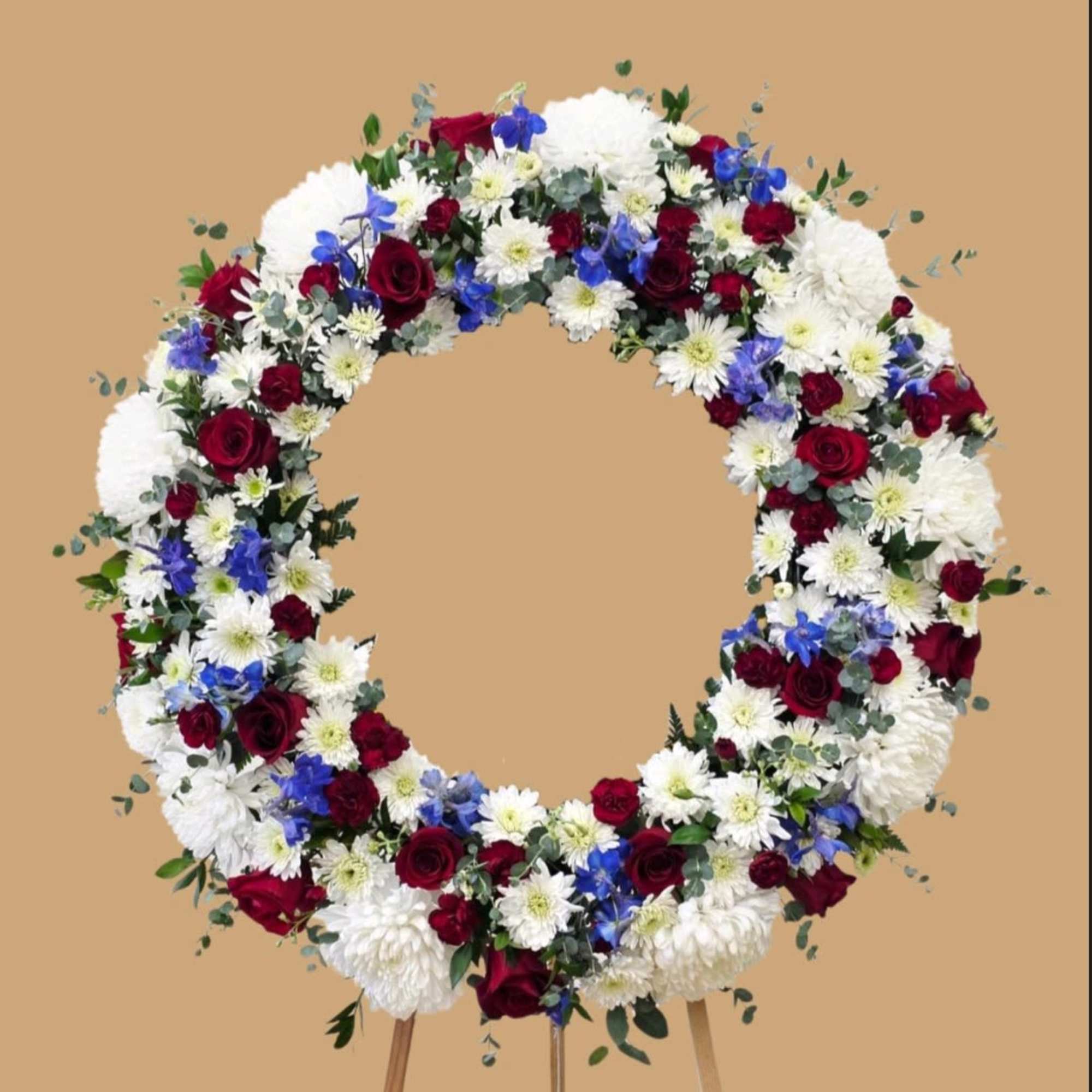 A formal circular wreath of deep red roses, snowy white chrysanthemums and