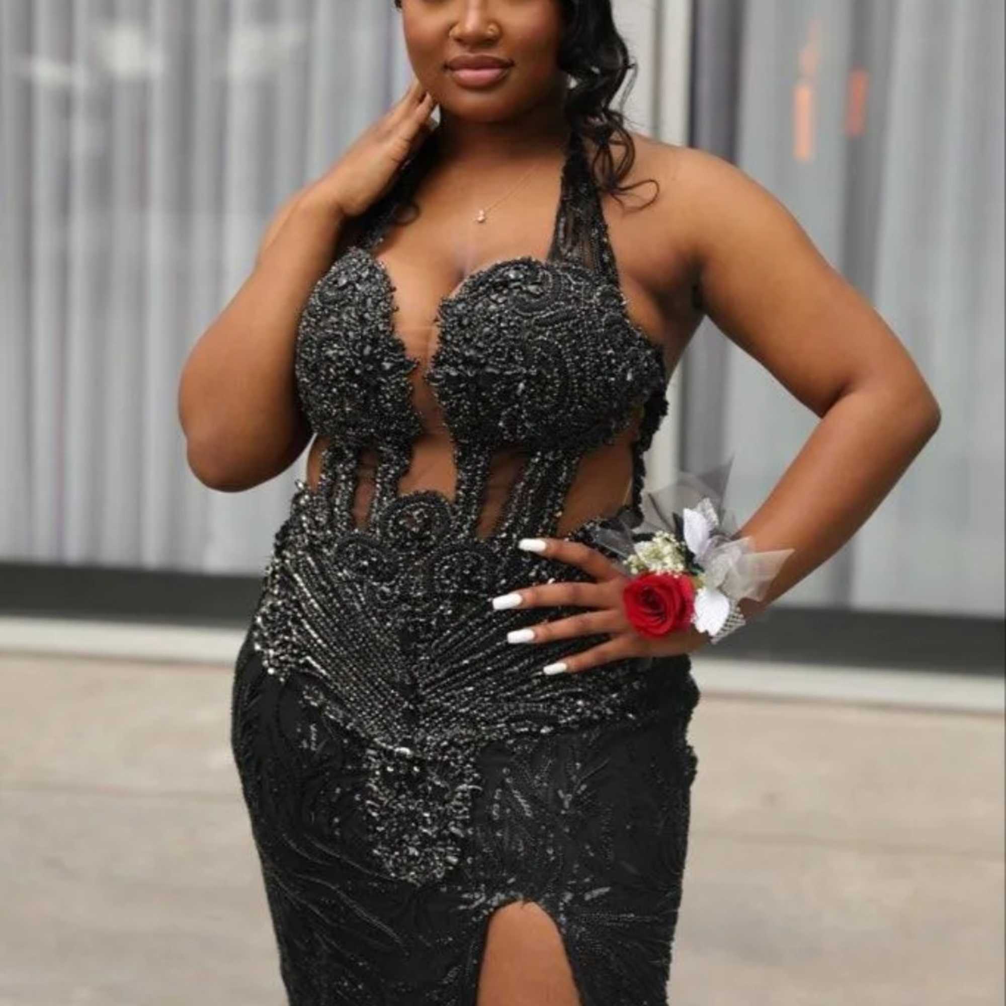 Woman in a black gown wearing a red rose corsage