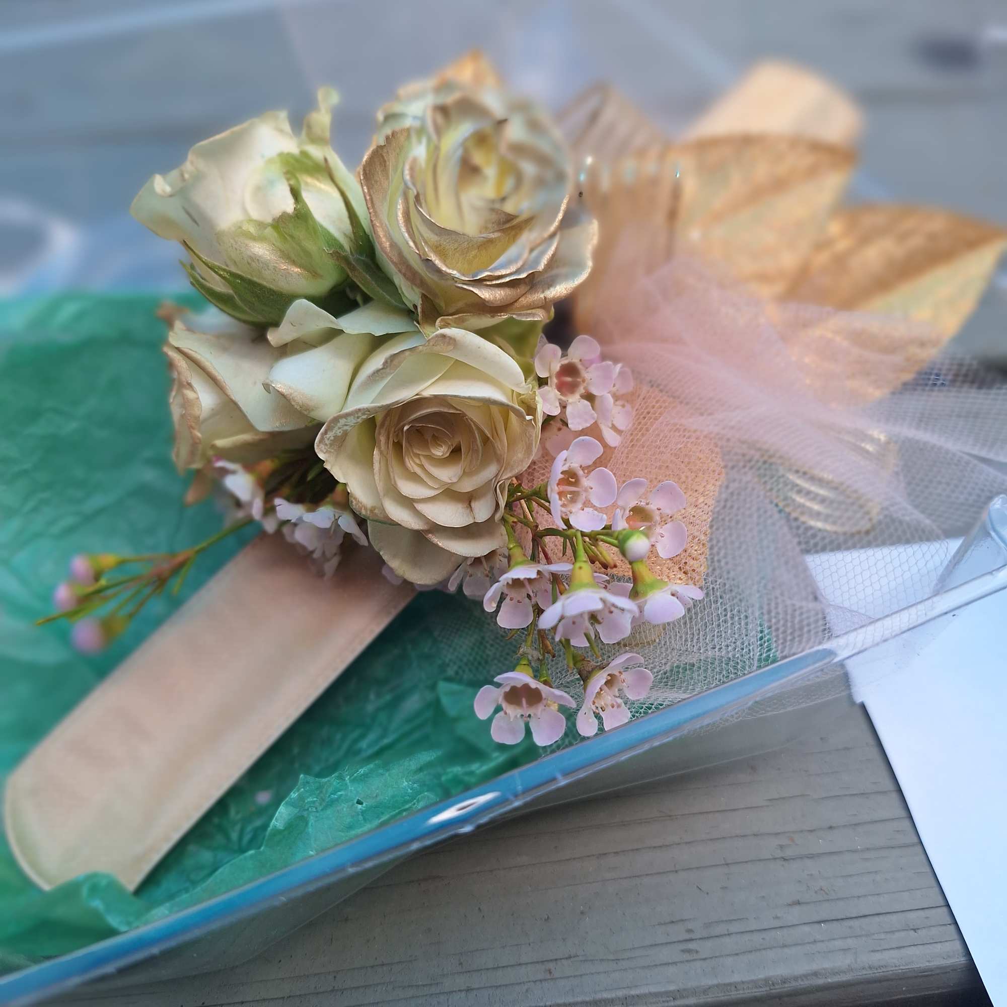 Small bouquet of cream roses with pink filler flowers and tulle wrap