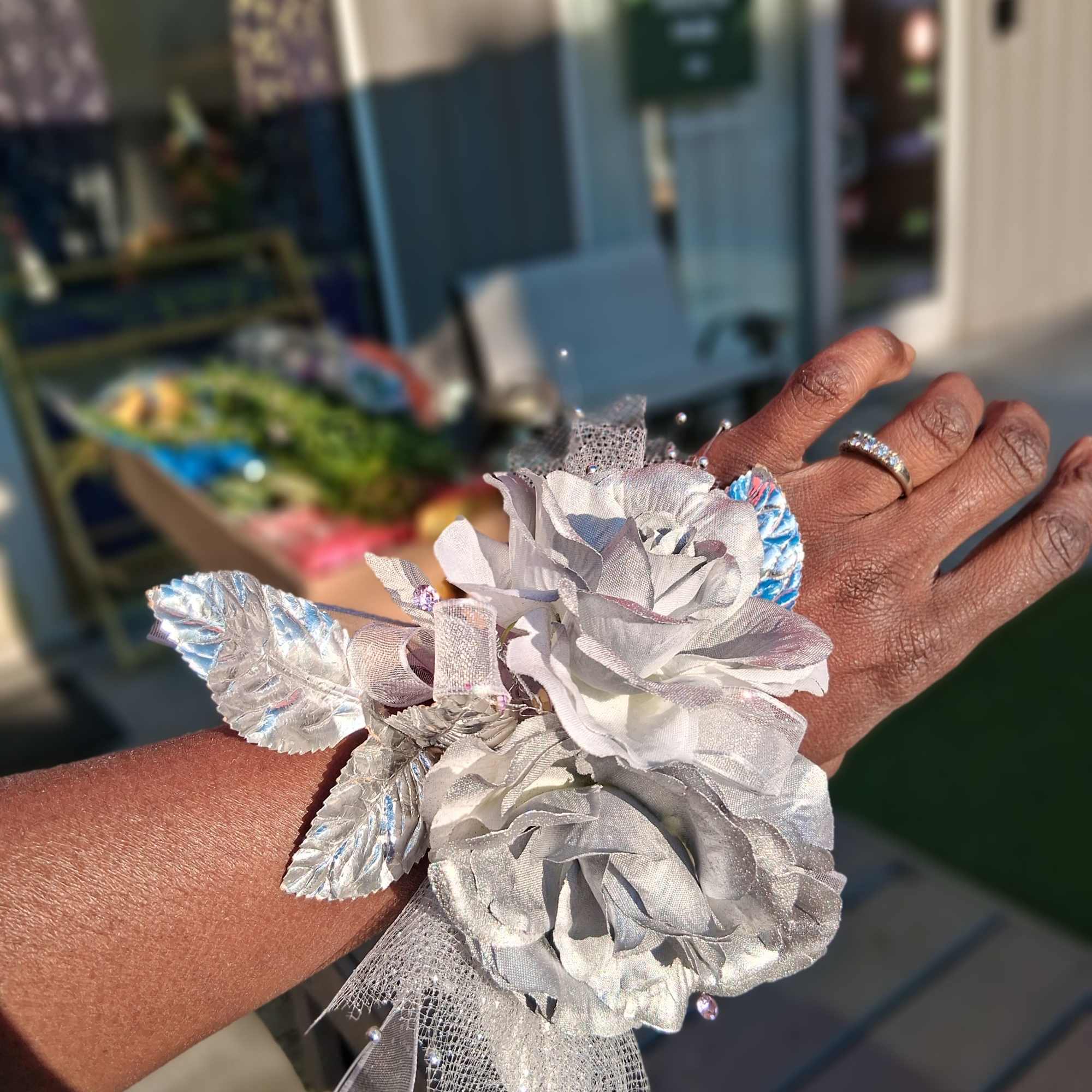 A lapel or wrist corsage with tulle, ribbon and blooms.
