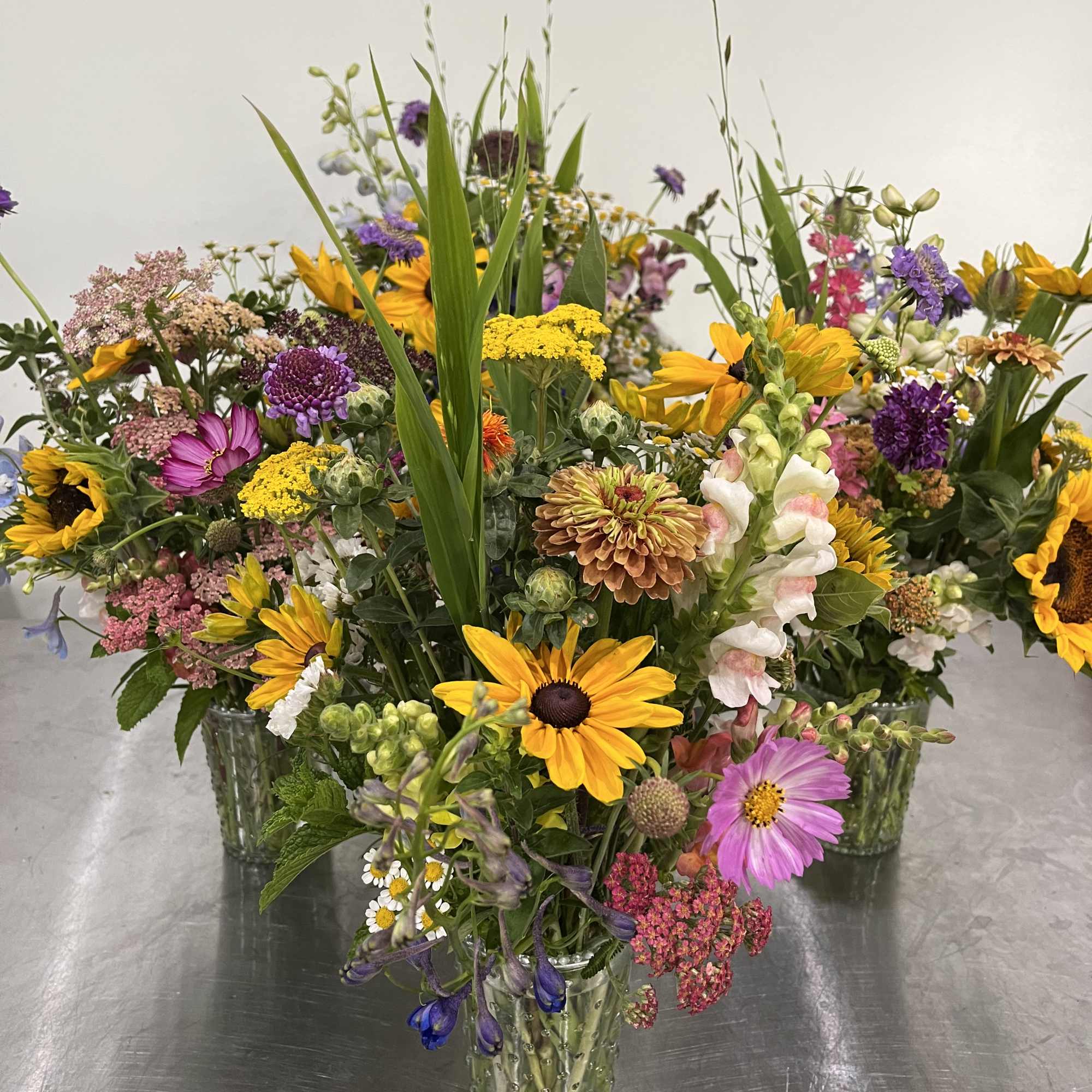 Cluster of small glass vases filled with colorful wildflower-style mixed bouquets