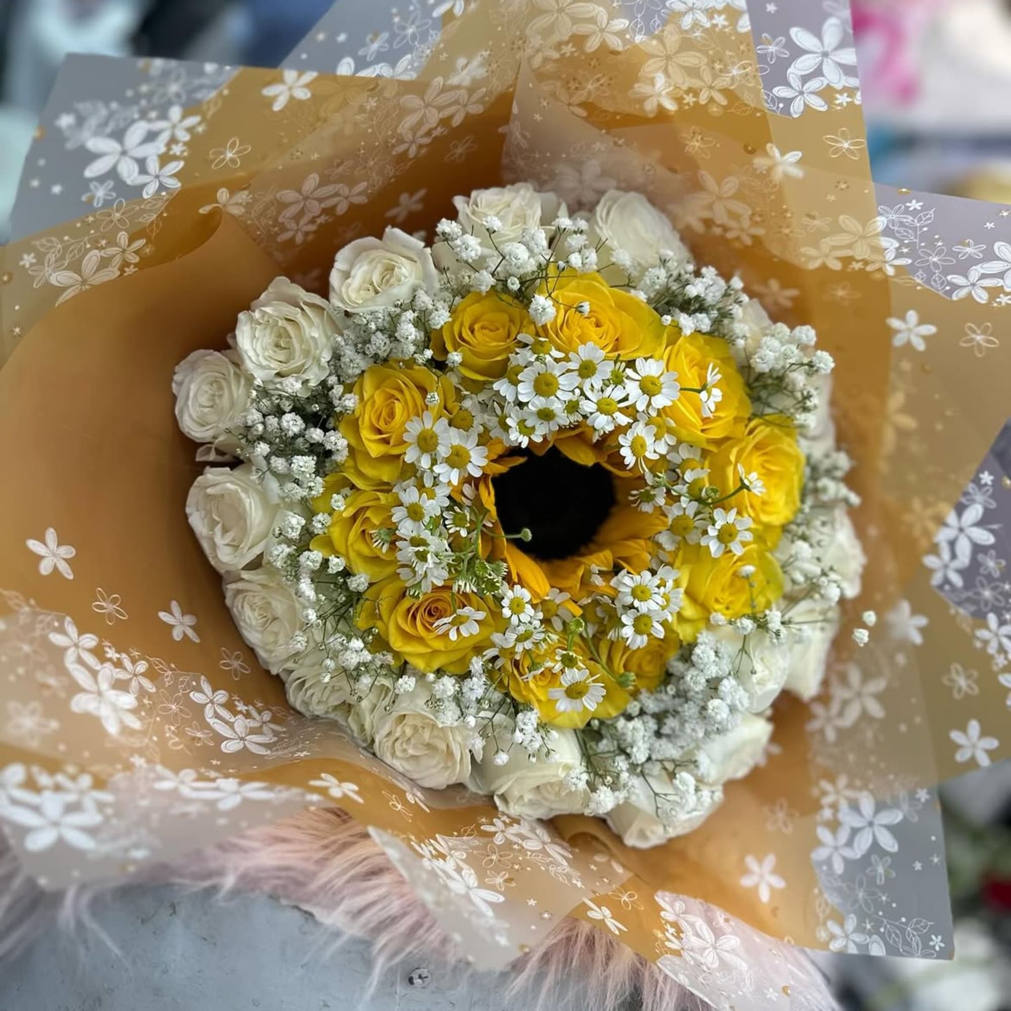 Yellow and white rose bouquet with small white daisies in floral wrap