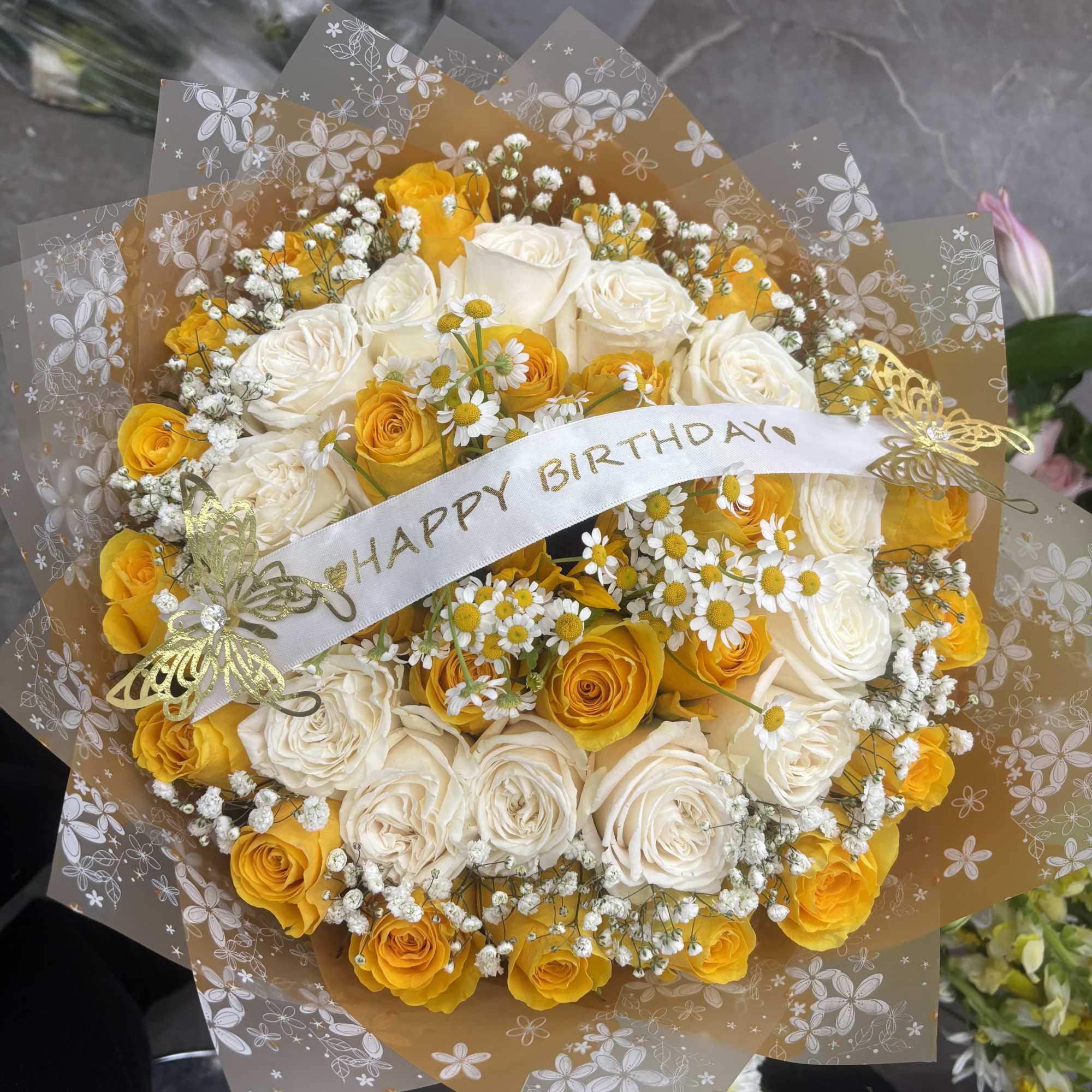 Bouquet of yellow and white roses with a birthday ribbon