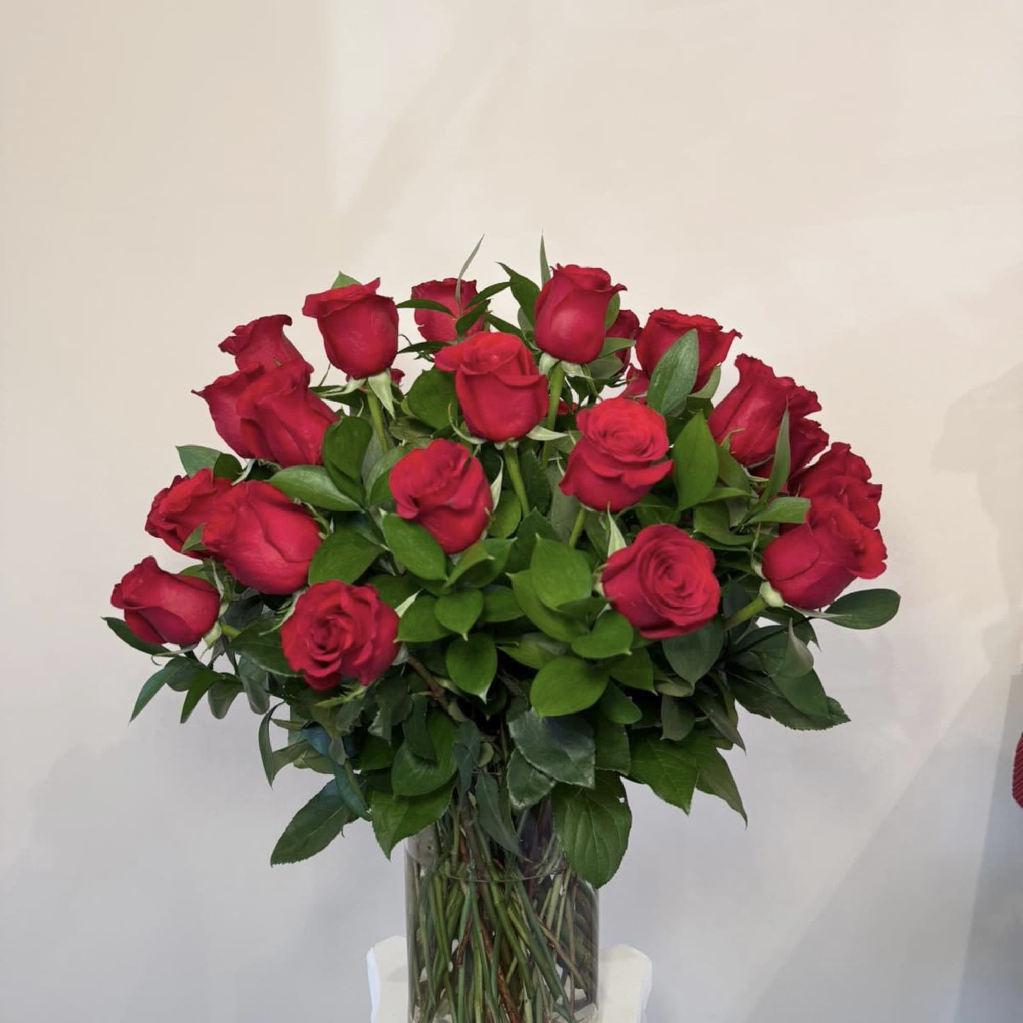 Red roses arranged in a clear glass vase
