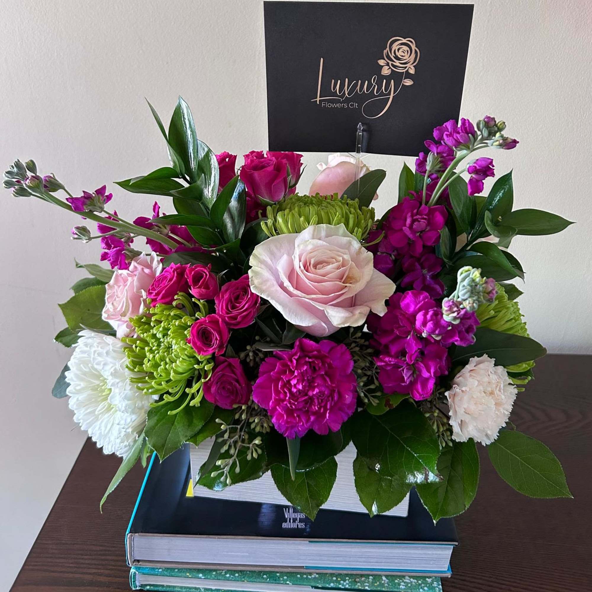 Pink and white roses with magenta blooms in a white box arrangement
