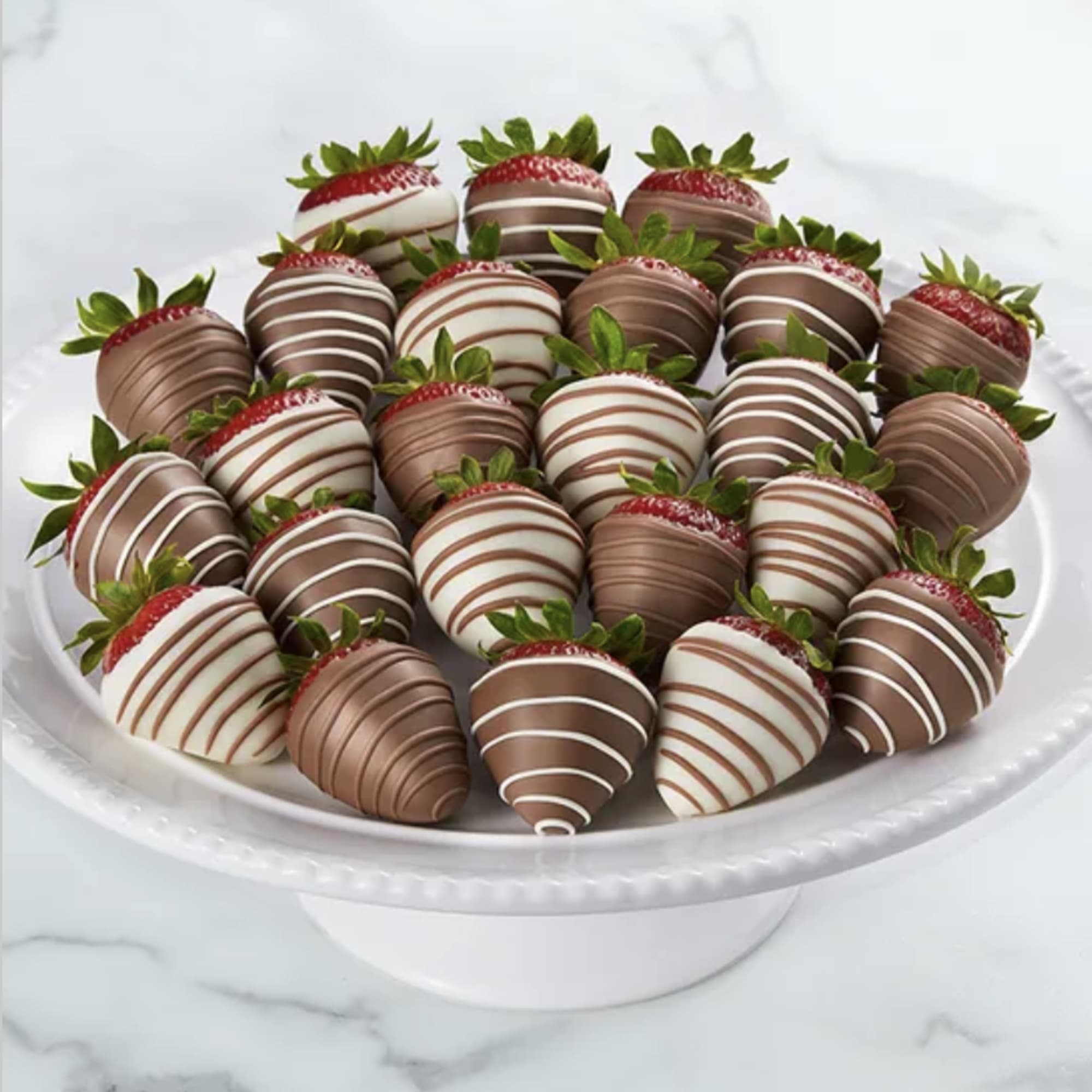 Plate of chocolate-covered strawberries with white and dark drizzle