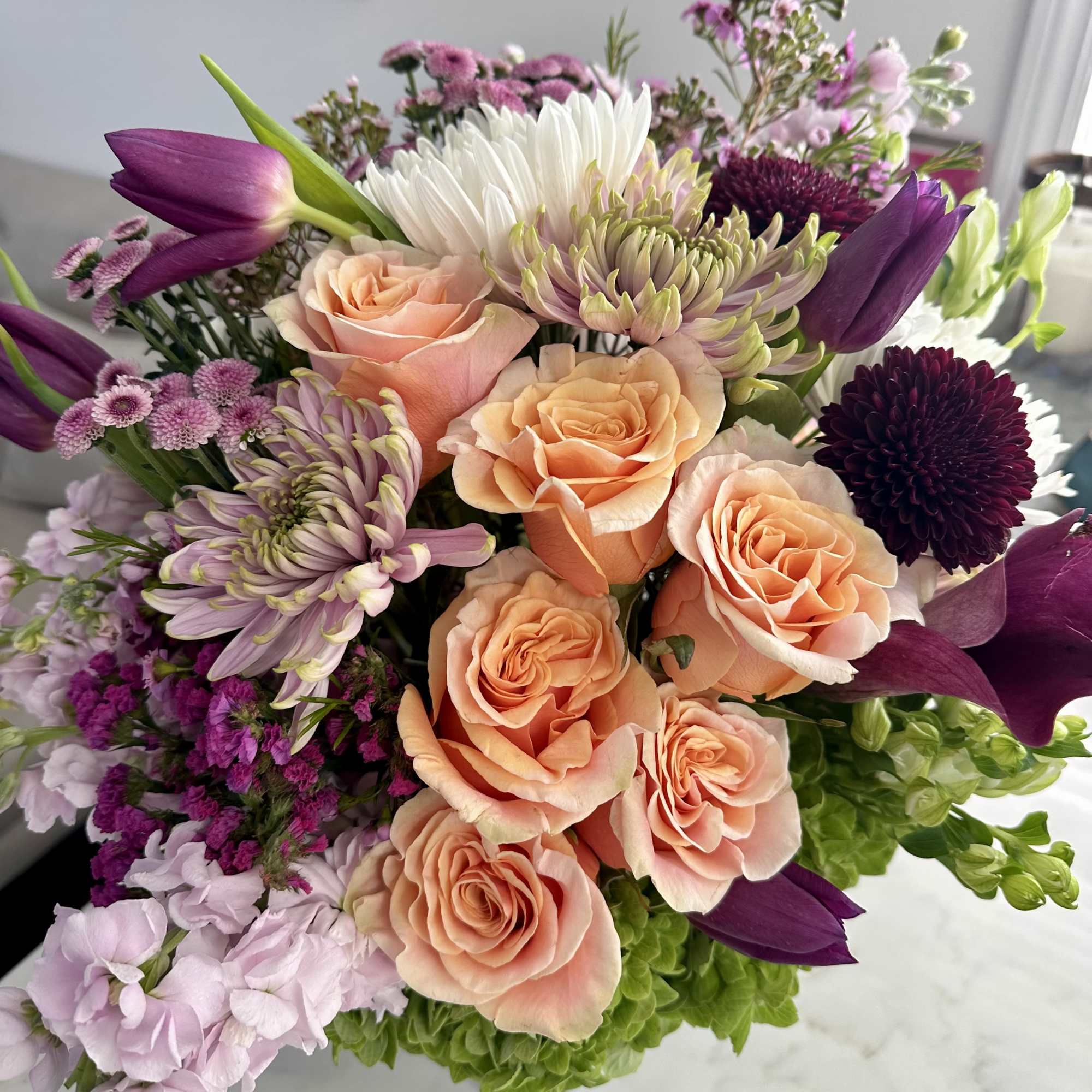 Bouquet of peach roses, purple tulips, and mixed chrysanthemums