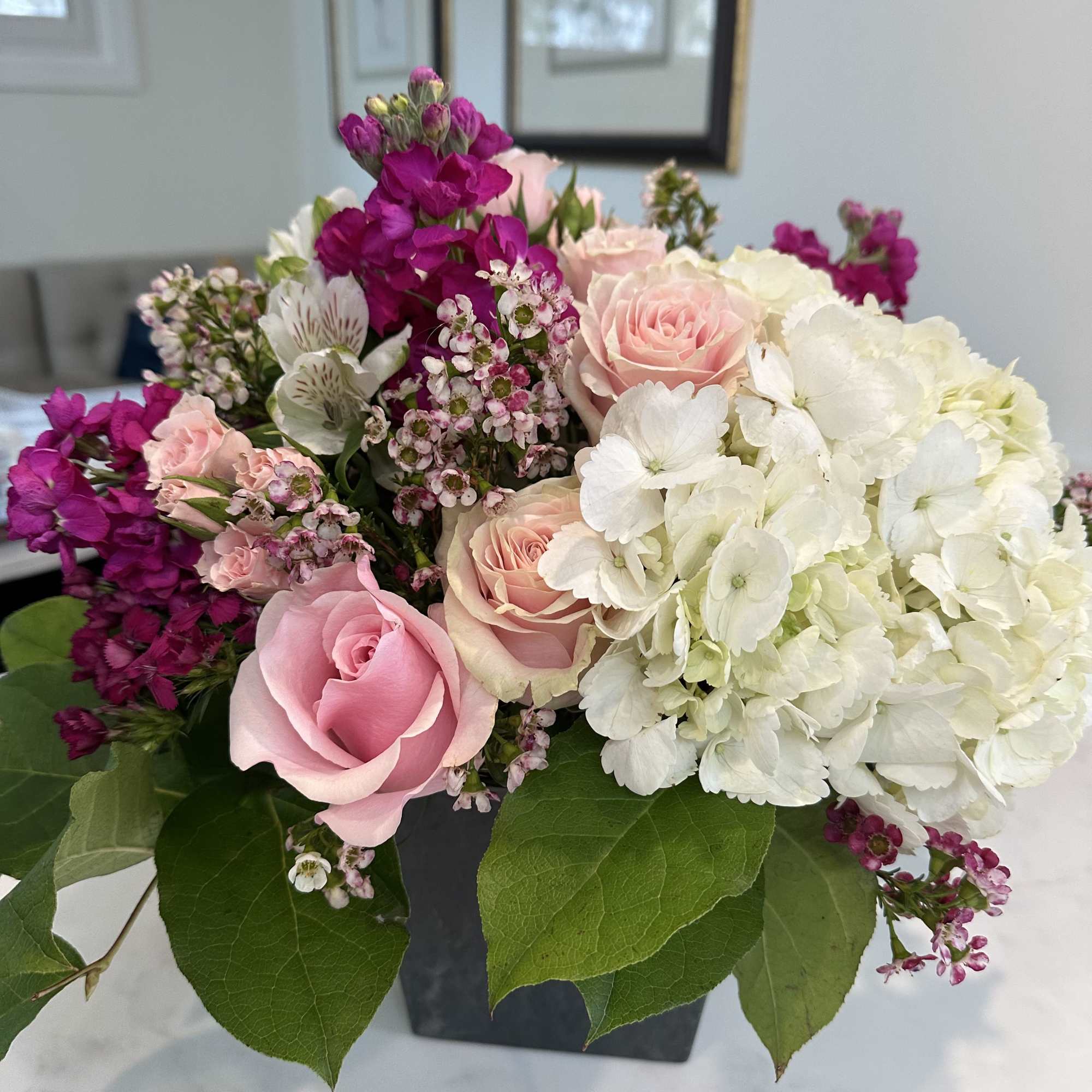 Pink roses and white hydrangeas in a black square vase