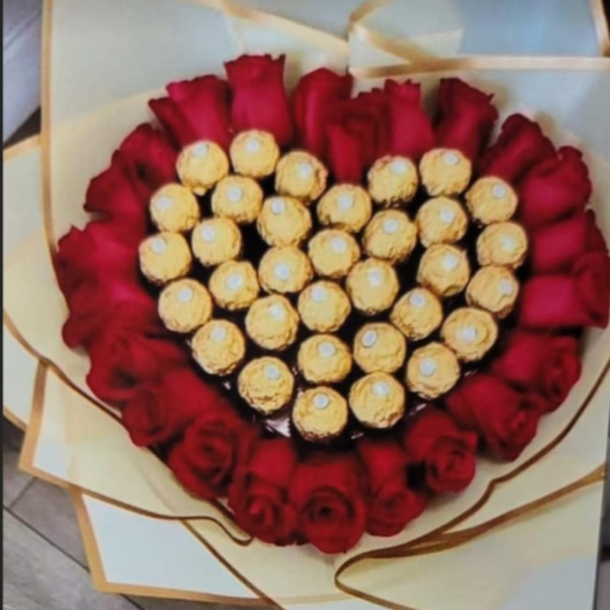 A heart-shaped cluster of deep red roses ringed around a glittering center