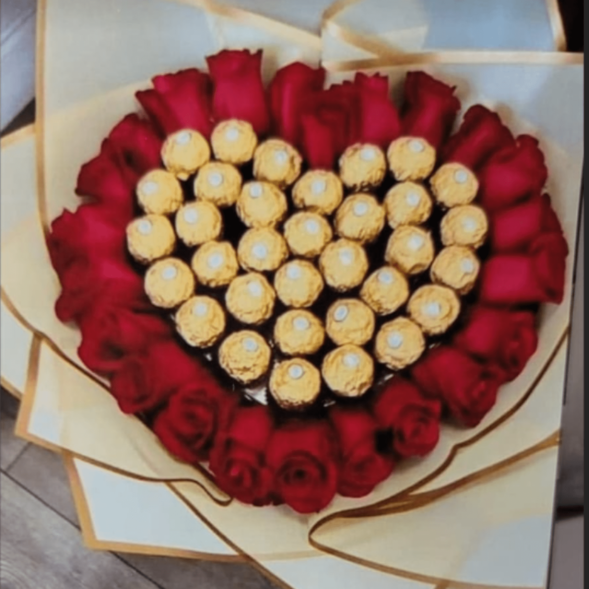A heart-shaped cluster of deep red roses ringed around a glittering center