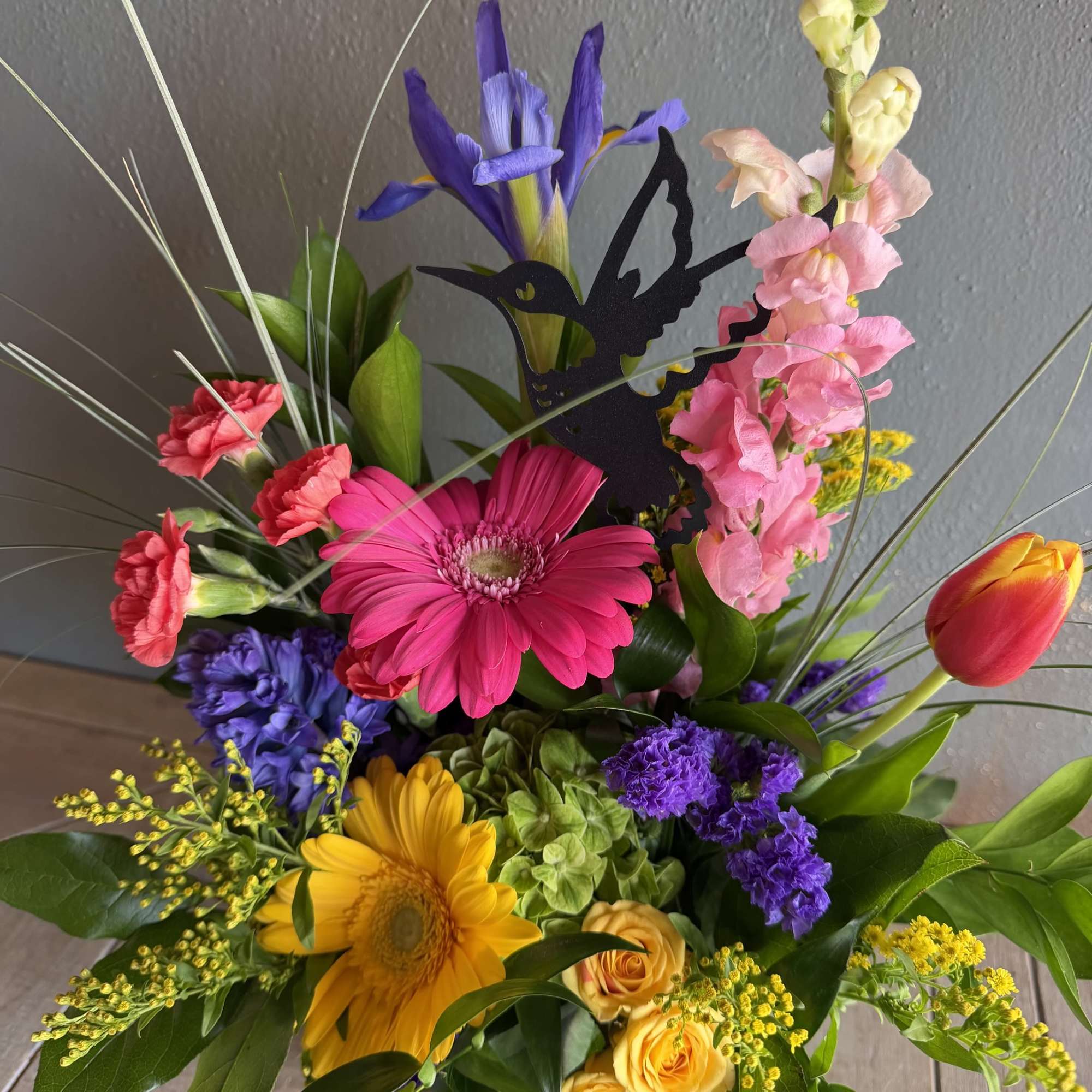 The playful hummingbird theme and contemporary low black container make this arrangement