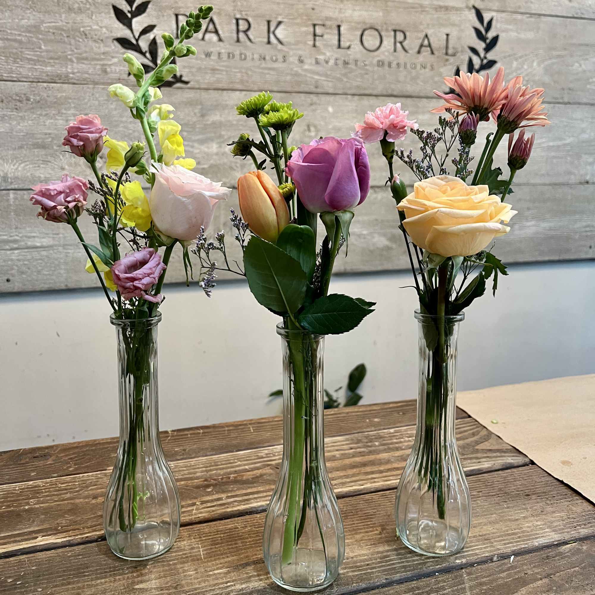 These petite arrangements pair roses, tulips, carnations, snapdragons, and small green chrysanthemums