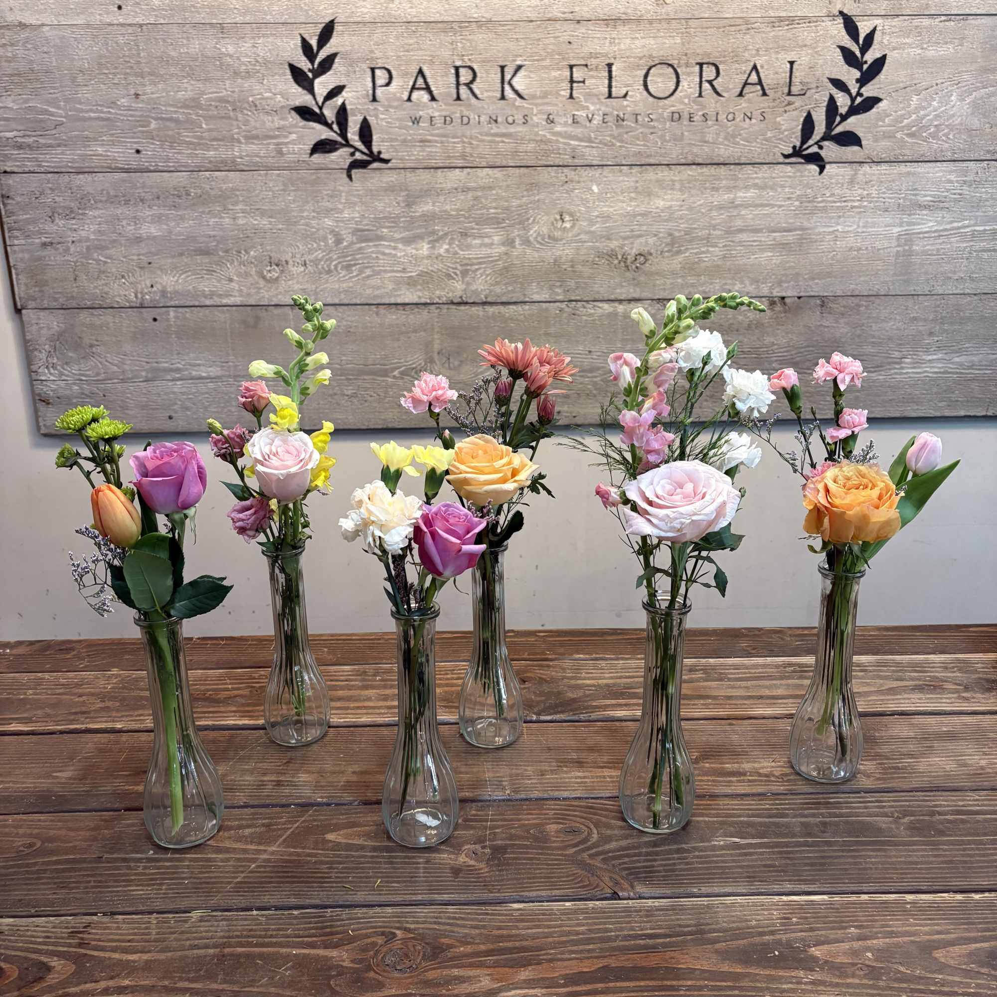 These petite arrangements pair roses, tulips, carnations, snapdragons, and small green chrysanthemums