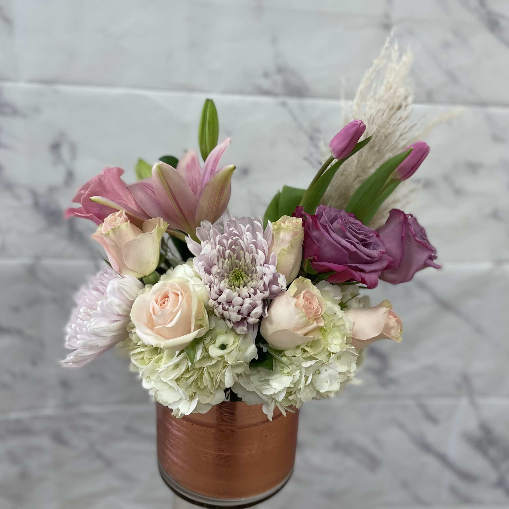 Pink and white floral arrangement in a copper-colored vase