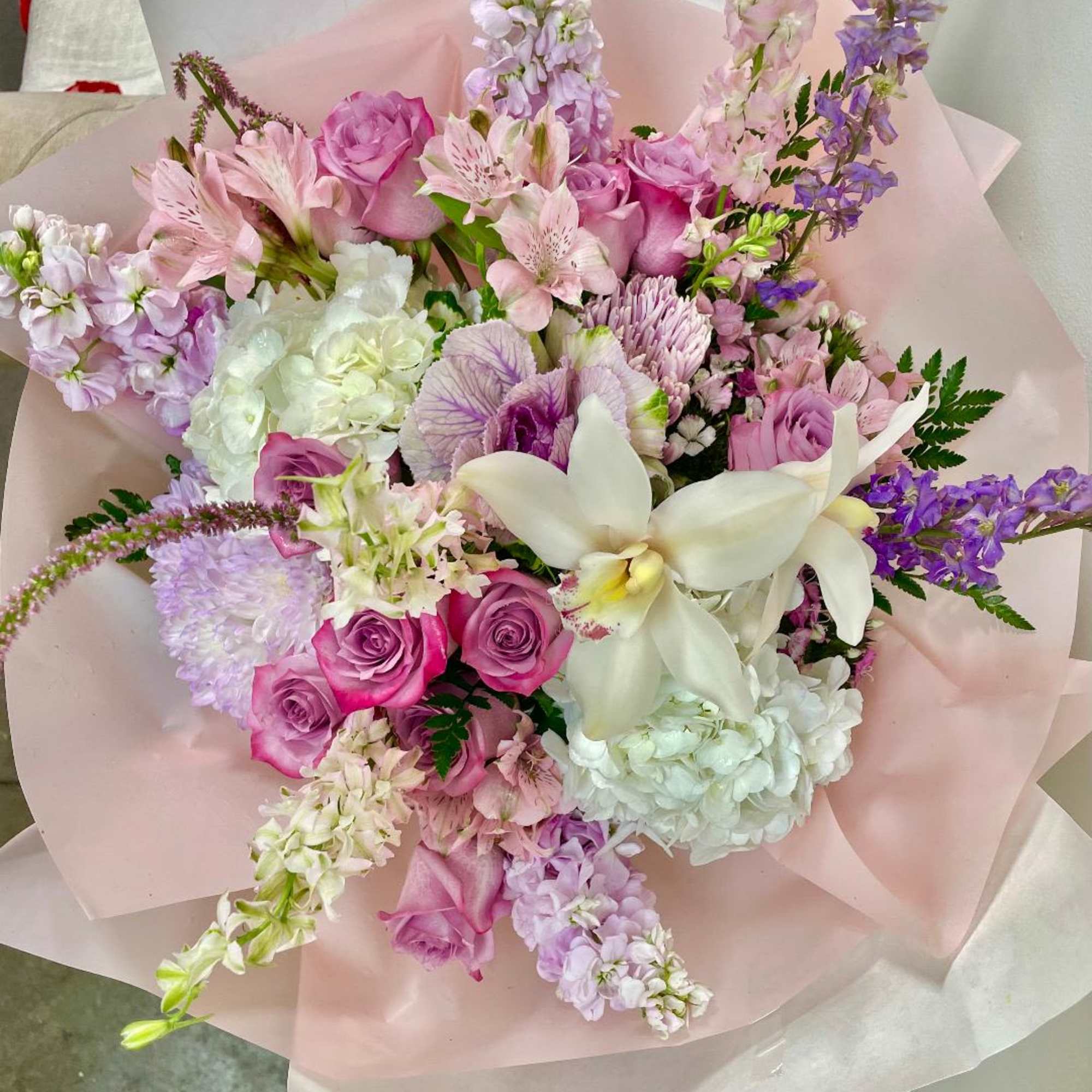 Pink and white mixed bouquet with roses, orchids, and hydrangeas