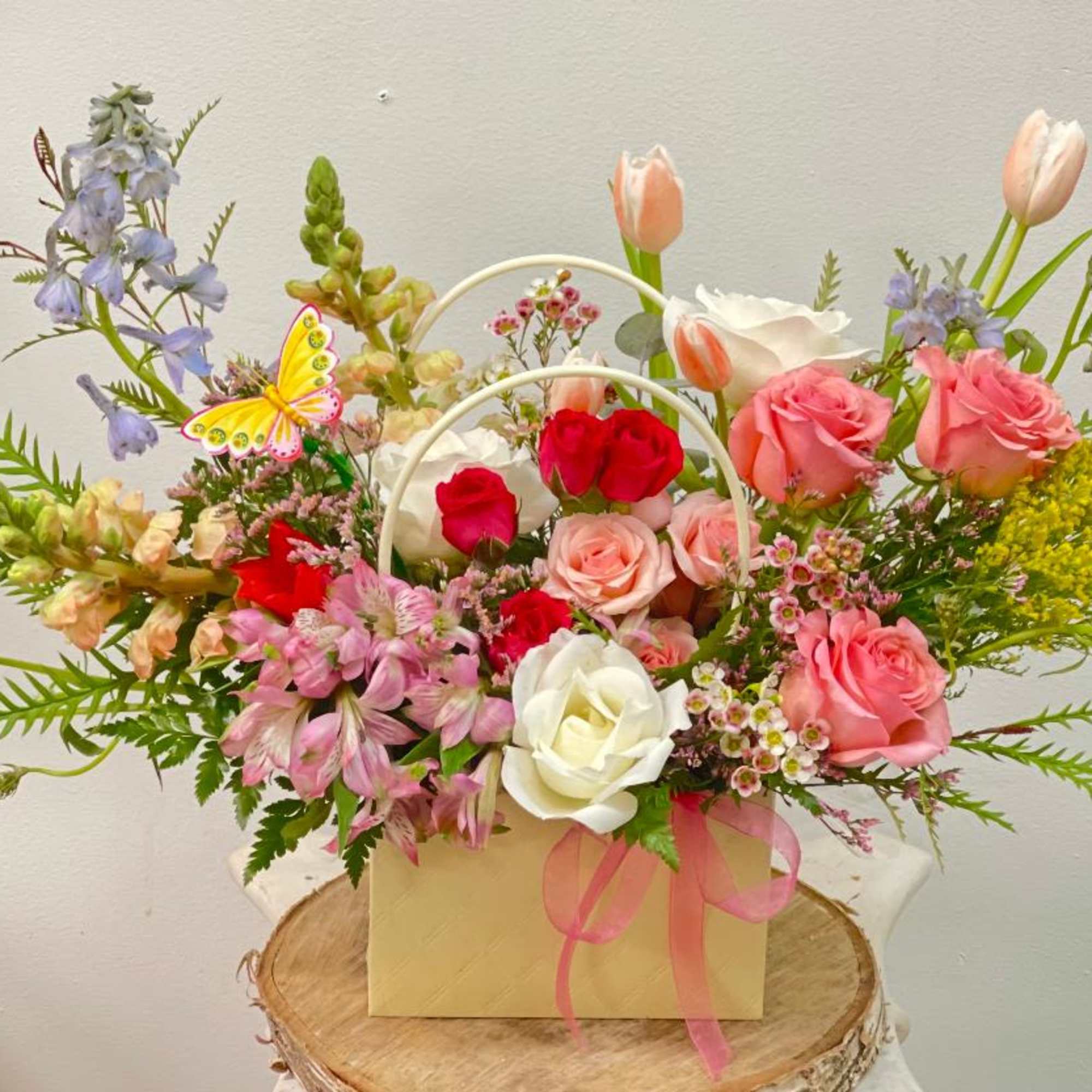 Mixed bouquet of roses, tulips, and alstroemeria in a gift box