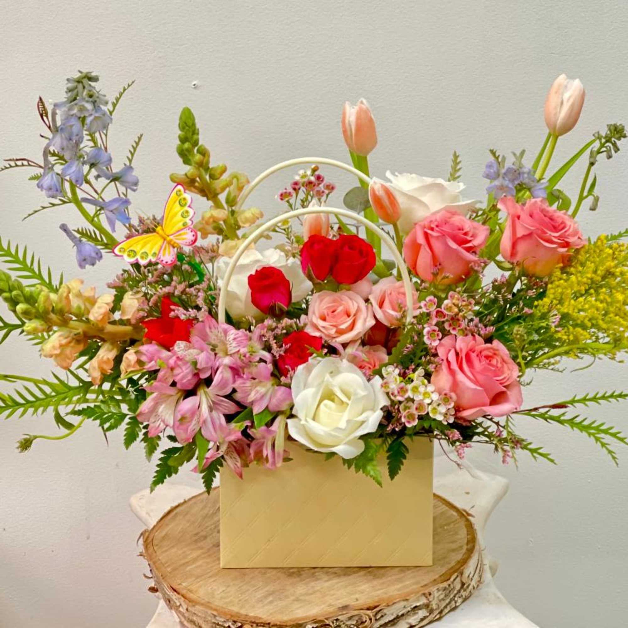 Mixed bouquet in a yellow handled box with pink and white roses and tulips
