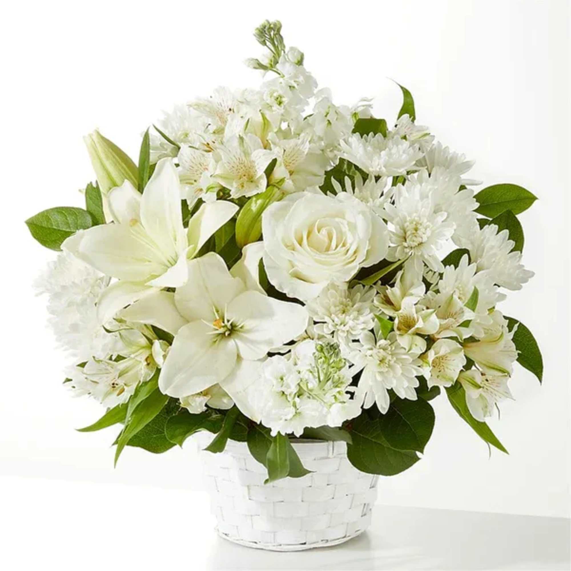 White floral arrangement in a white woven basket vase