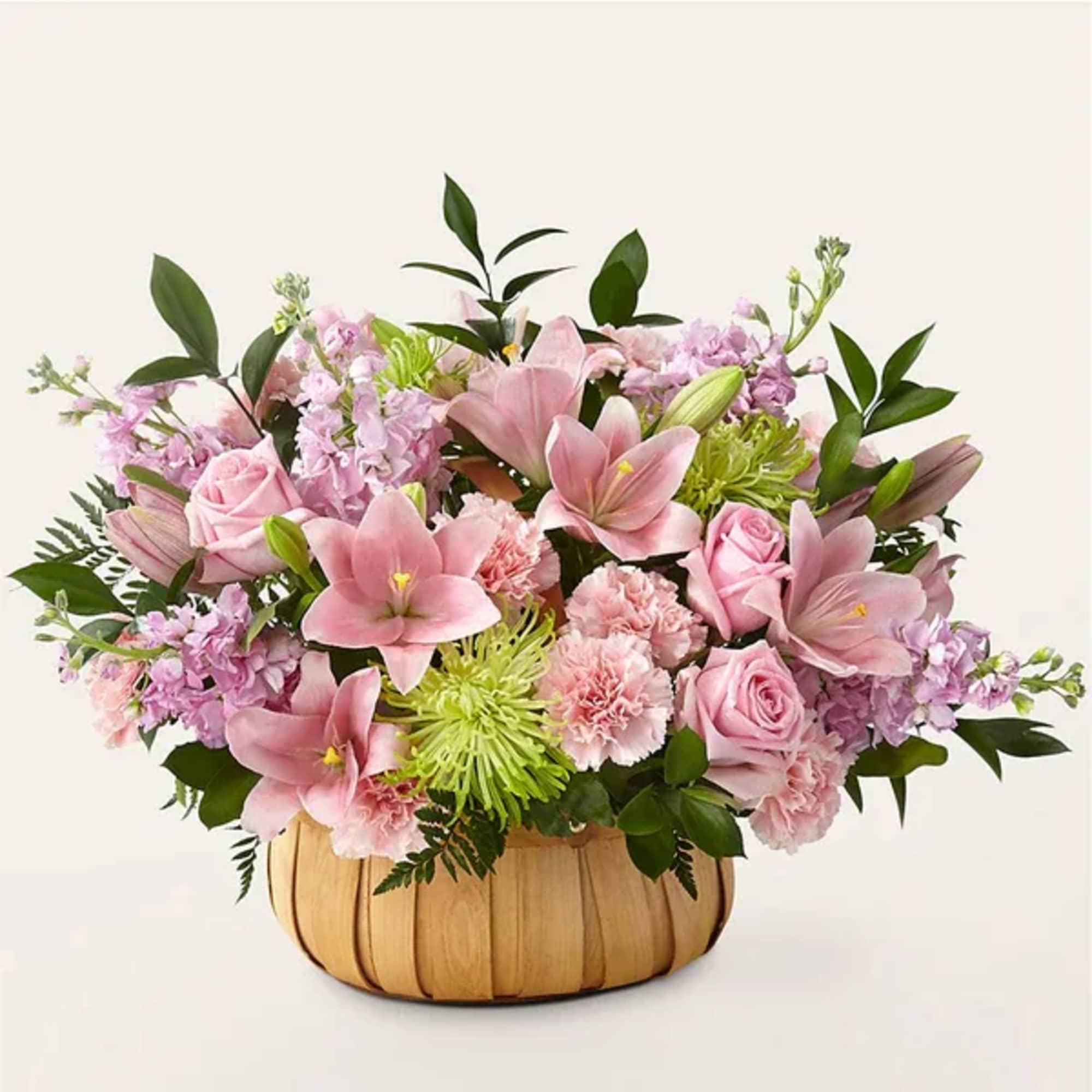 Pink lilies, roses, and carnations in a wooden basket
