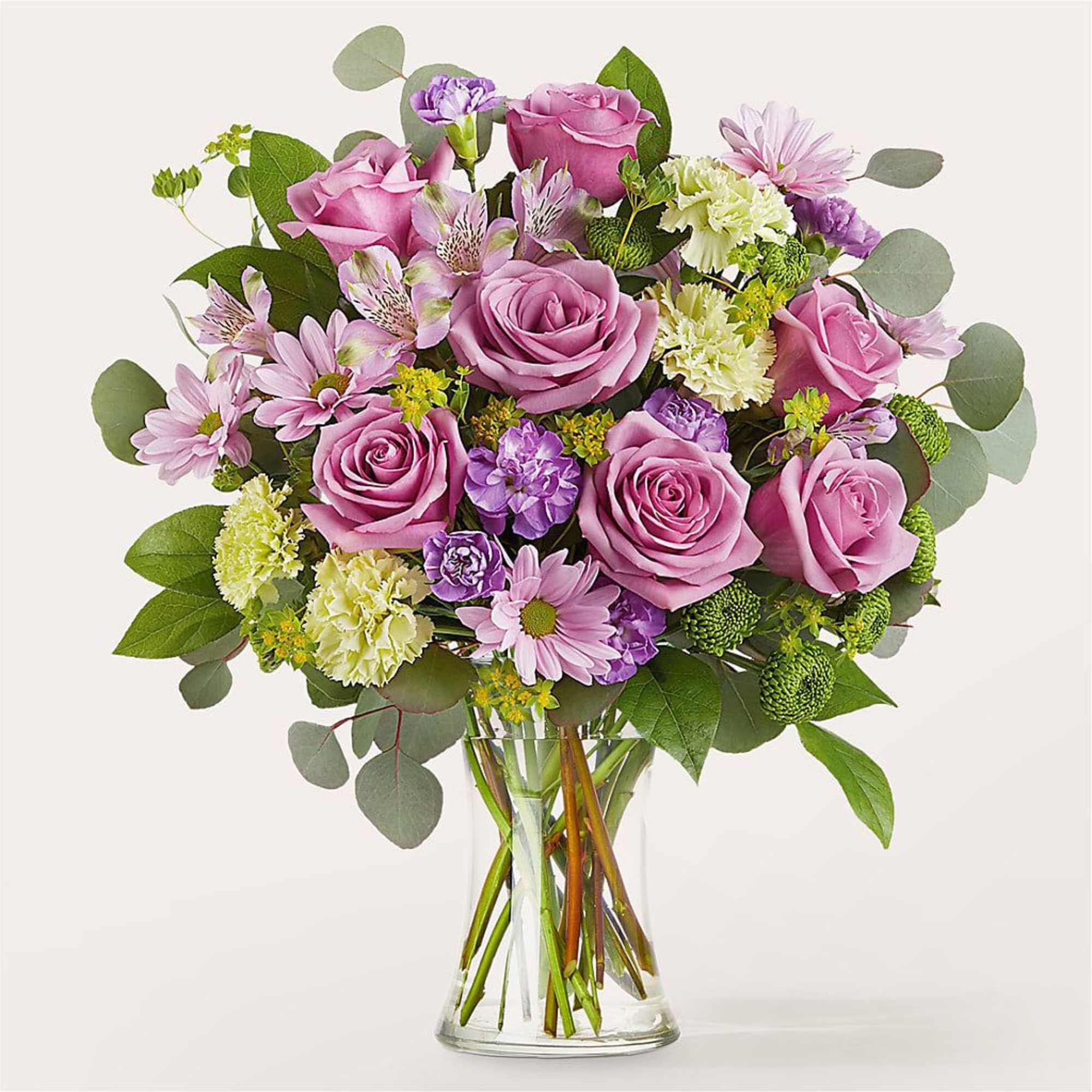 Pink roses and mixed blooms in a clear glass vase