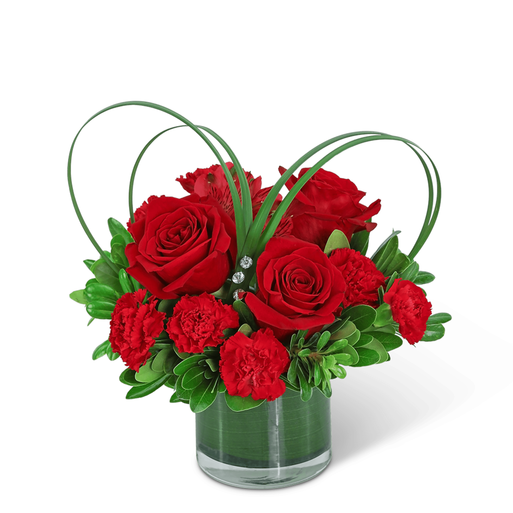Red roses and carnations in a clear glass vase with arched greenery