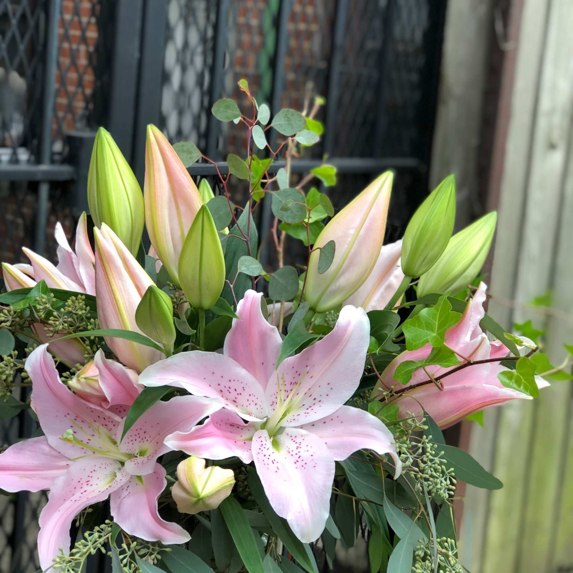 Pink lilies with unopened buds and greenery in a bouquet