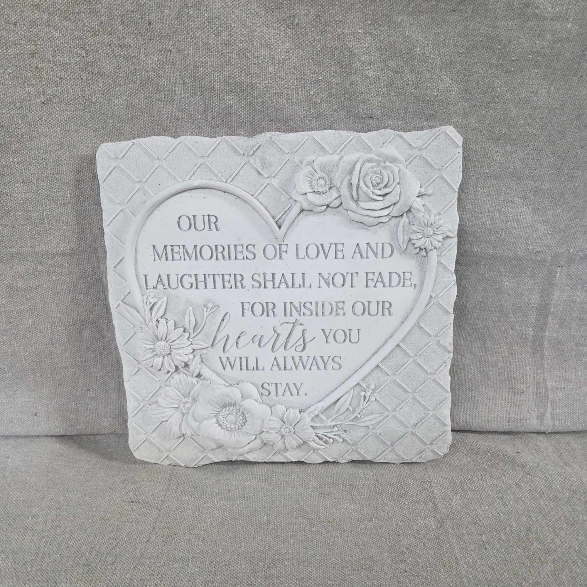 Gray stone sympathy plaque with heart-shaped inscription and carved flowers
