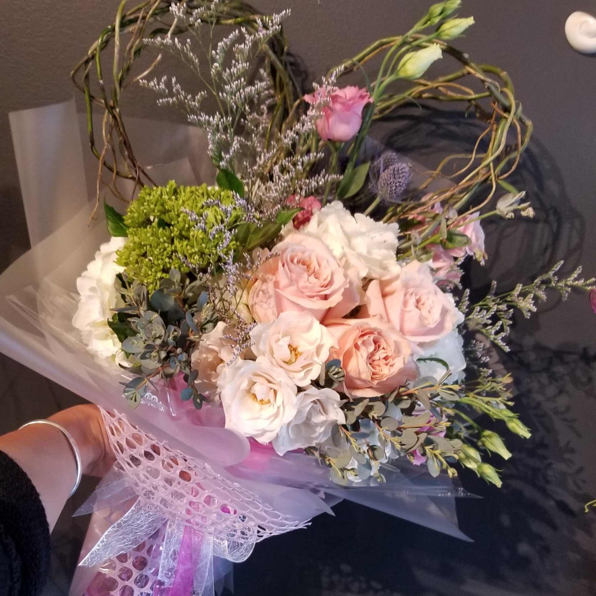 Bouquet of blush roses and white blooms with decorative twigs