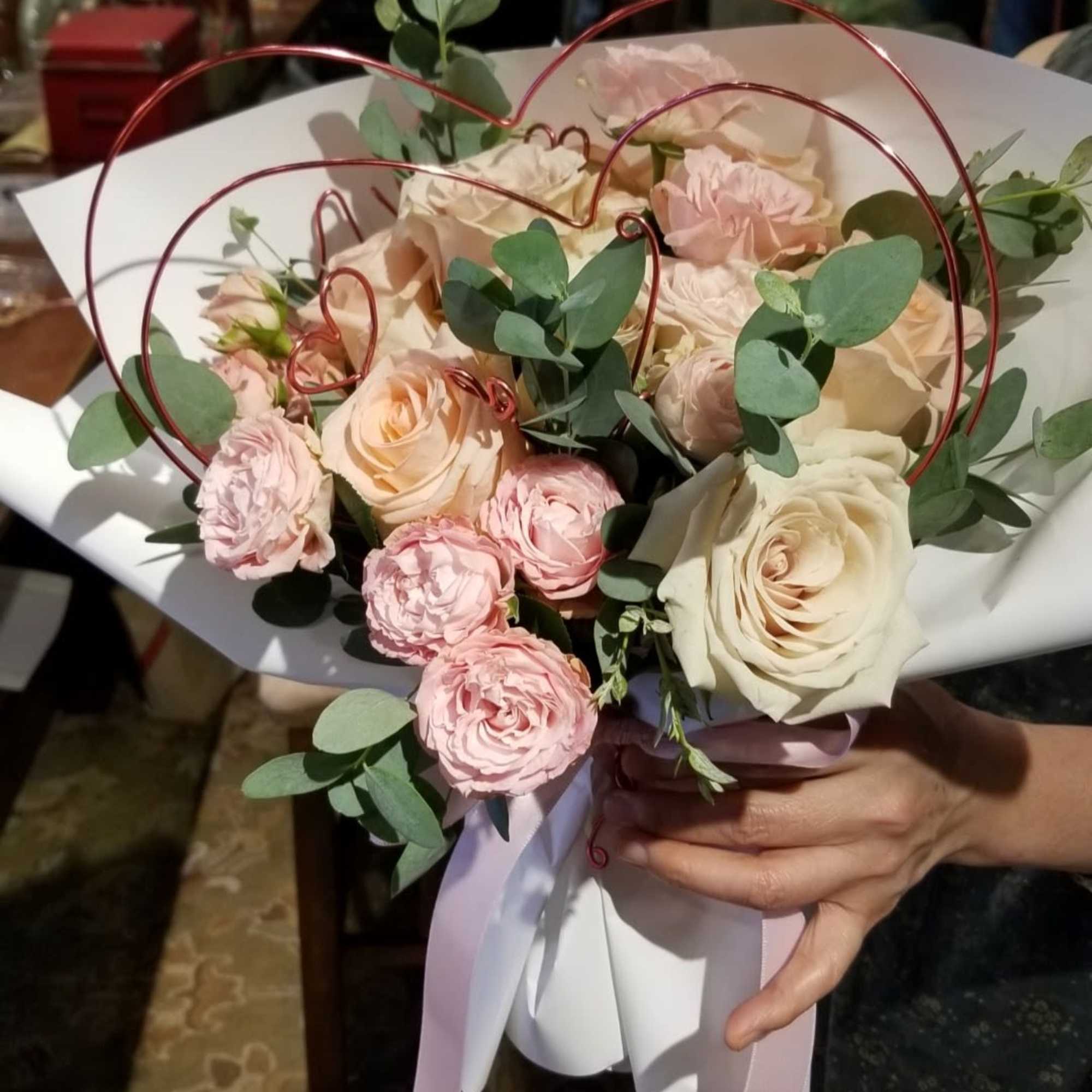 Bouquet of blush and cream roses with eucalyptus in white wrap
