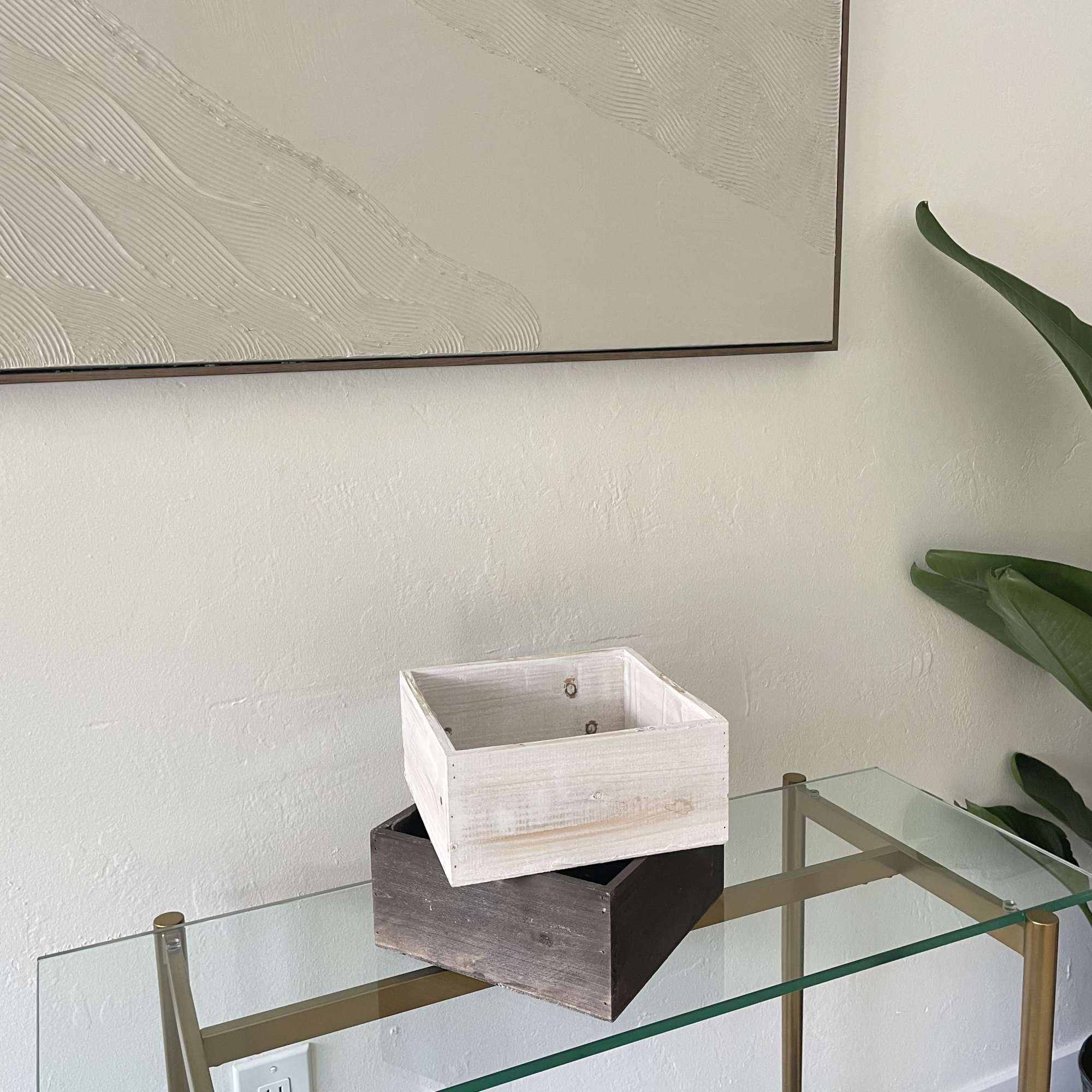 Two empty wooden crates stacked on a glass table.