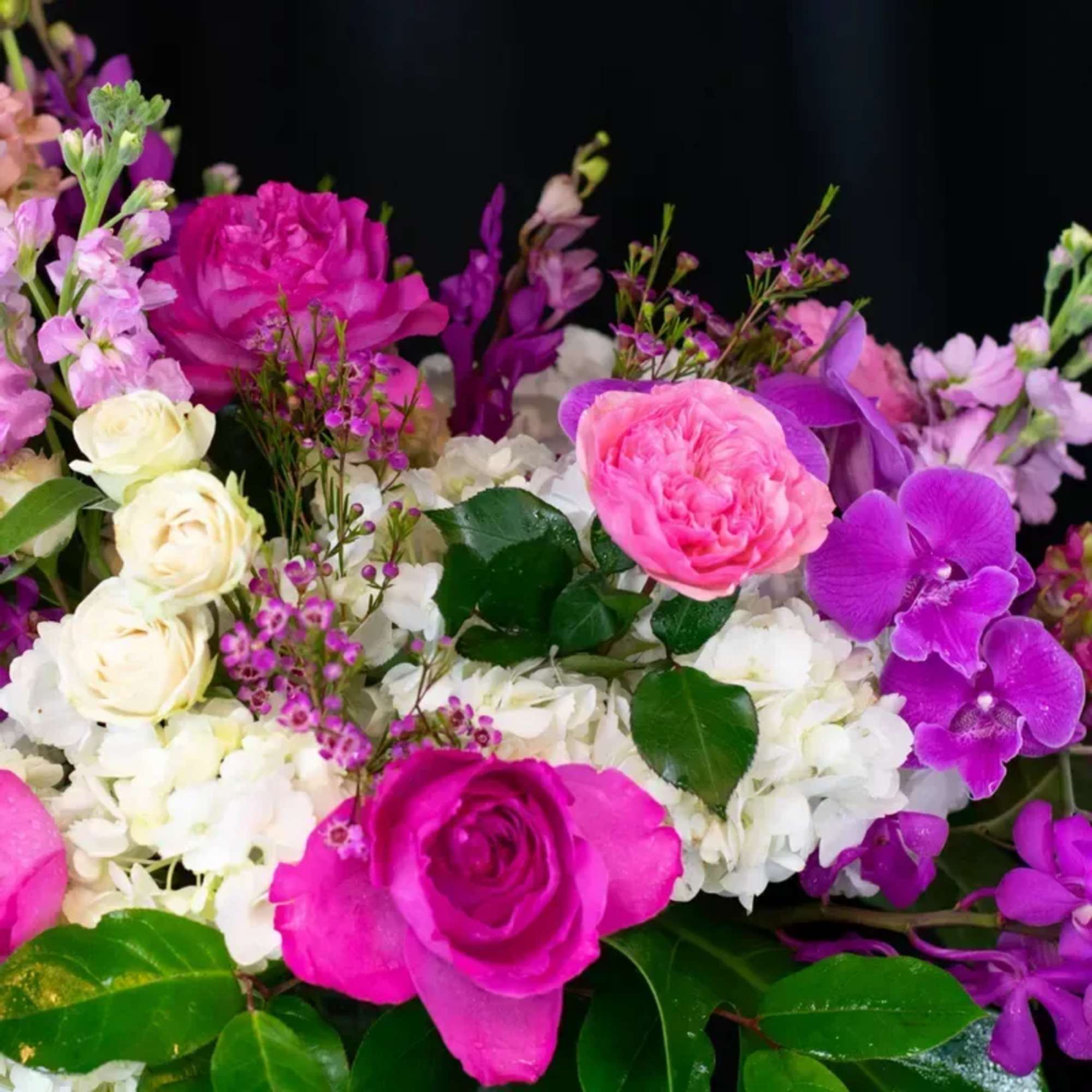 A stunning and very lush floral creation using garden roses, orchids and
