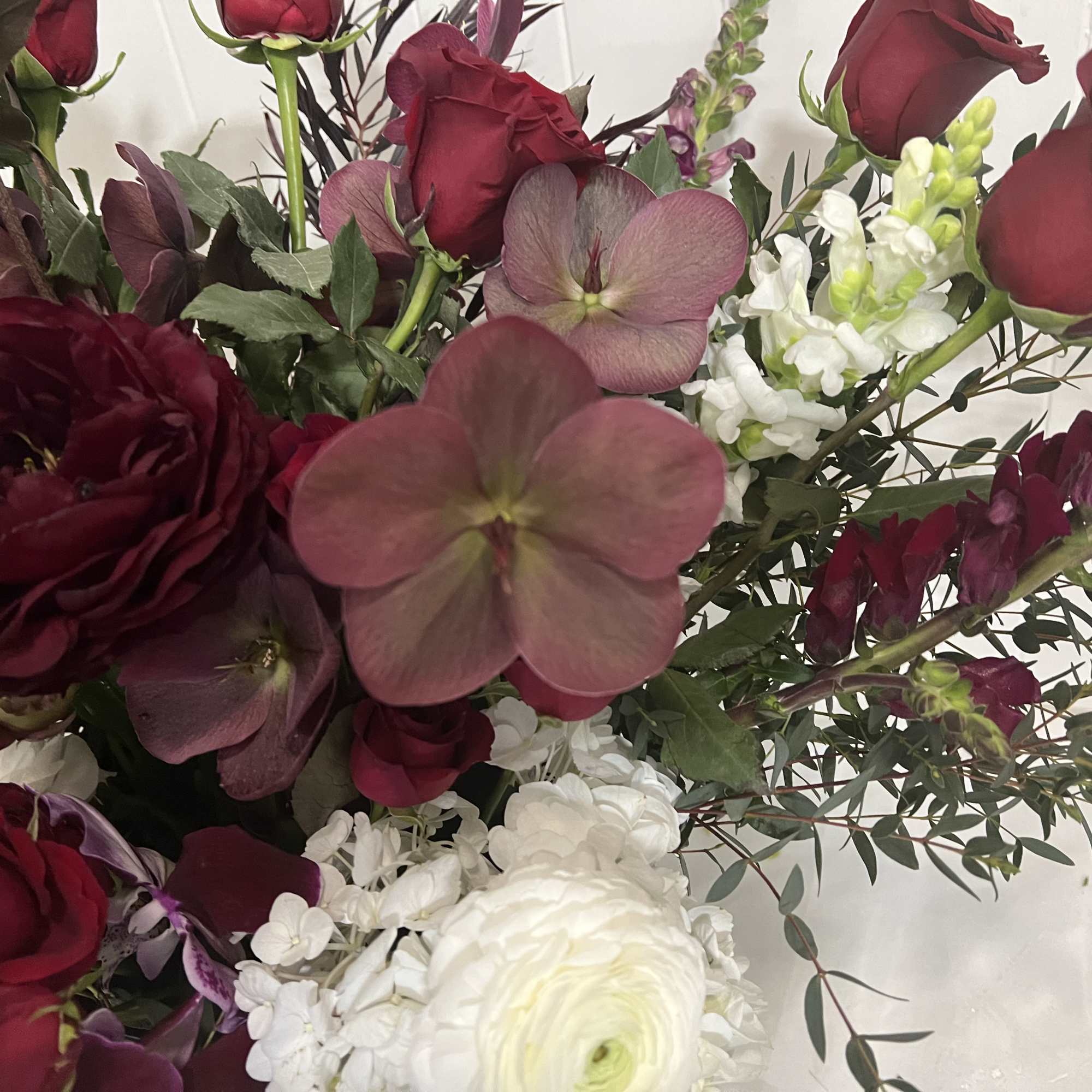 Bouquet of deep red roses and white blooms with greenery