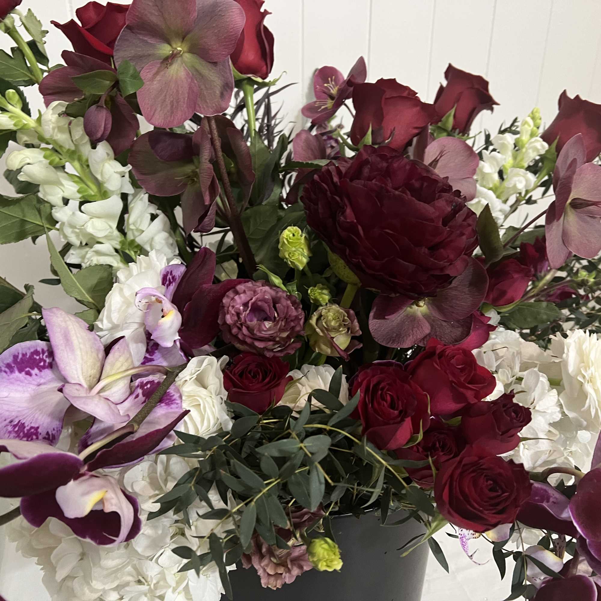 Large bouquet of burgundy and white flowers in a black vase