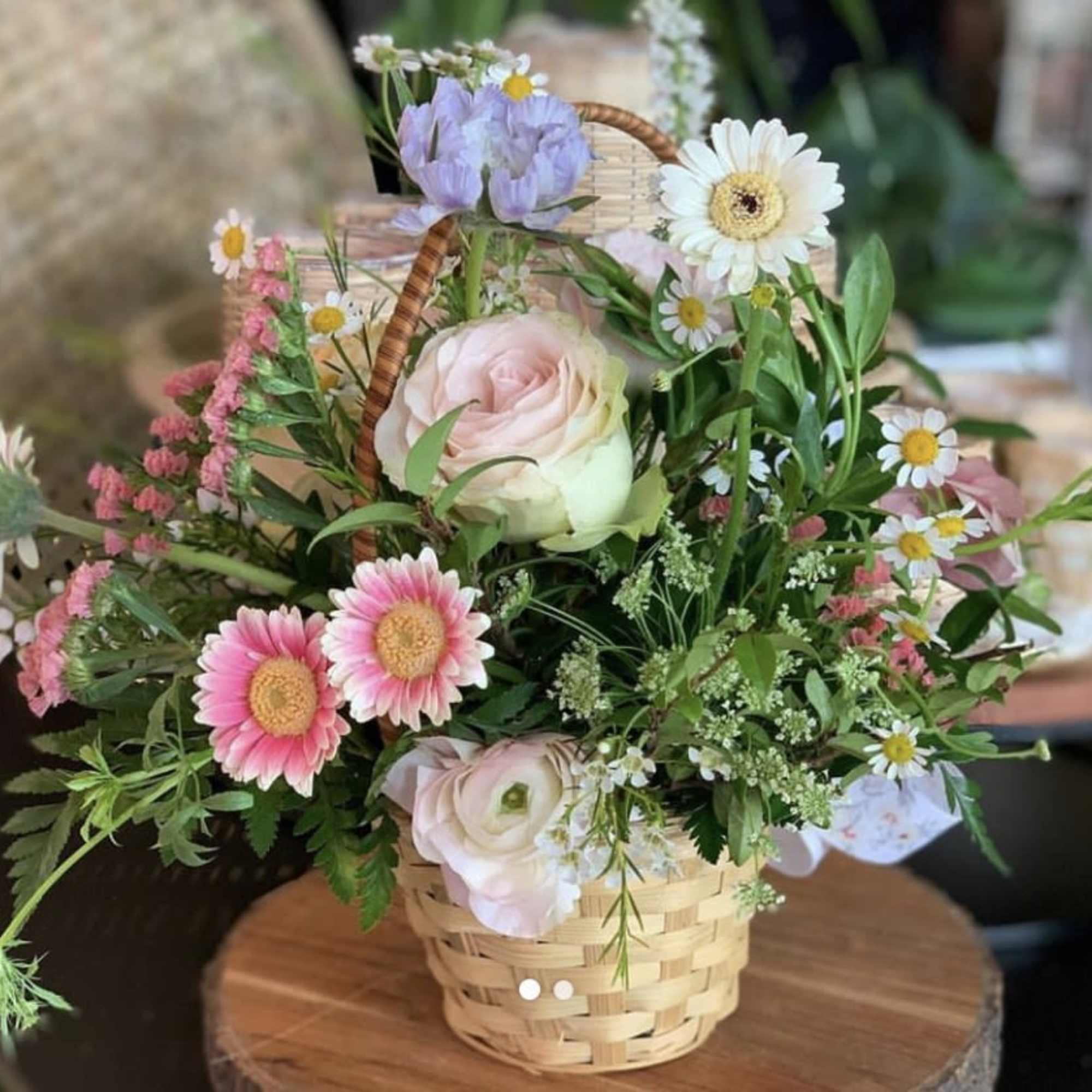 Basket arrangement of pink and white flowers with daisies and roses