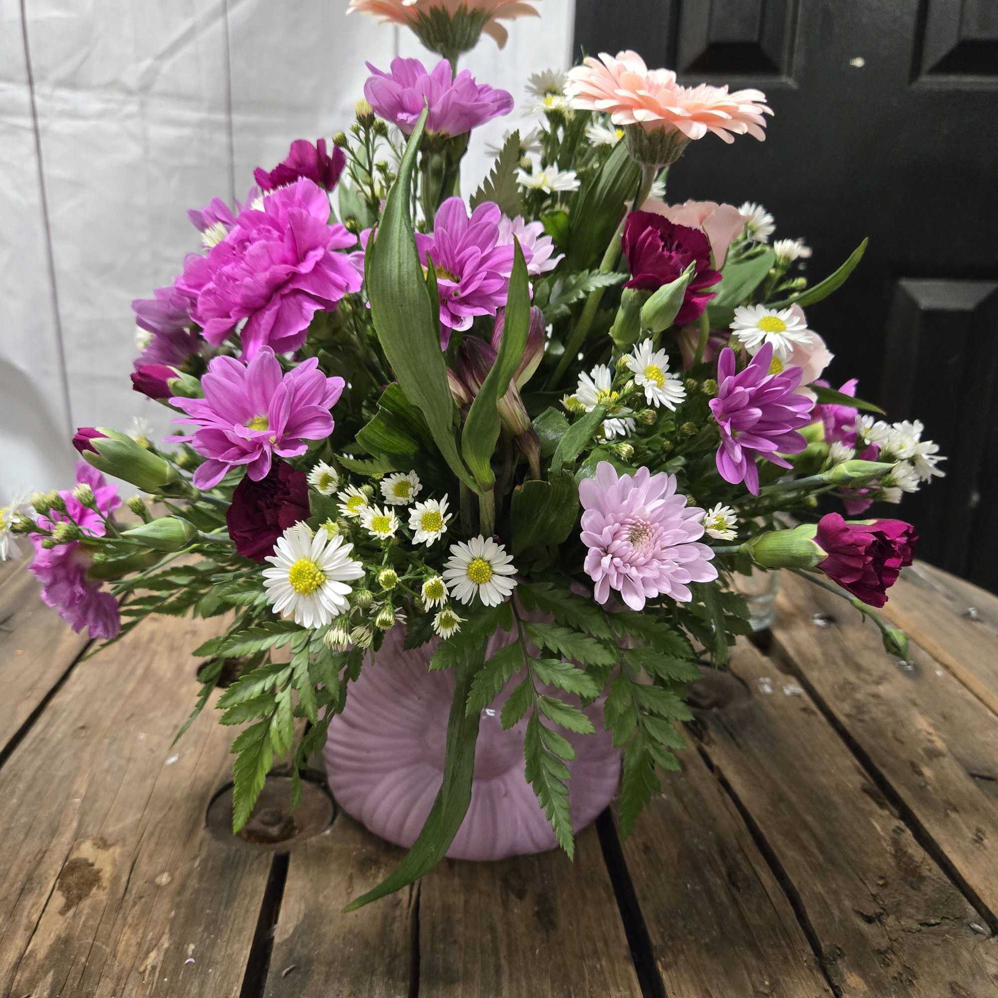 Full, garden-style mix of daisies, carnations, chrysanthemums, and gerbera in a soft