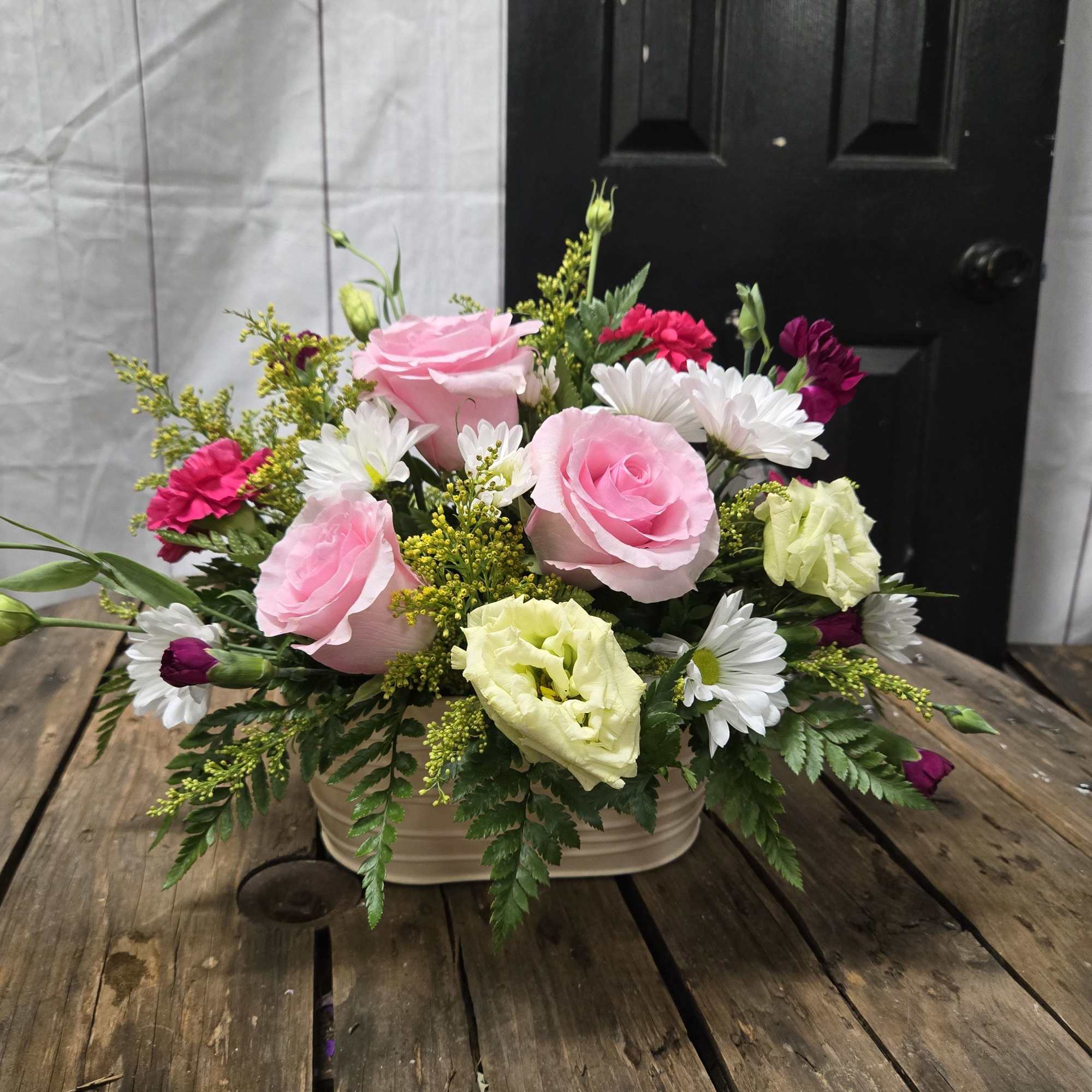 Low, garden-style mix of roses, daisies, carnations and fillers in a rectangular