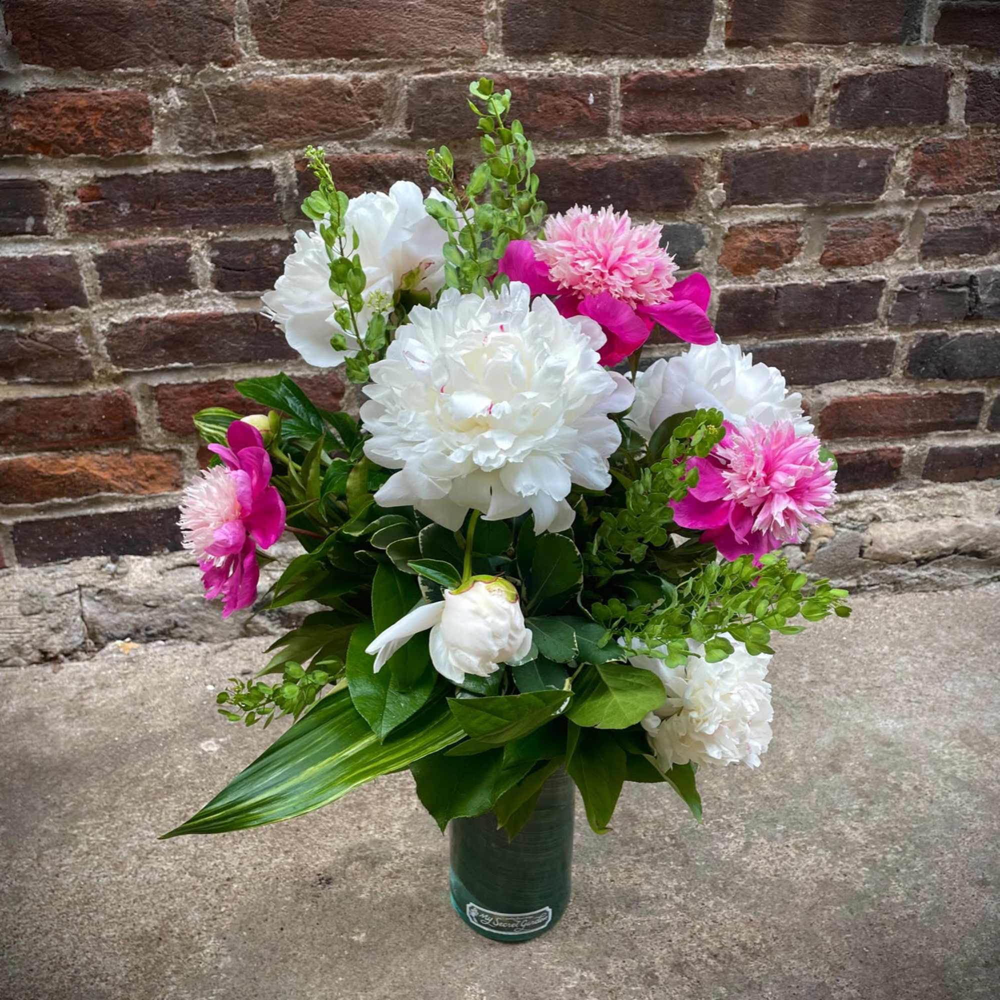 Bouquet of white and pink flowers in a green vase