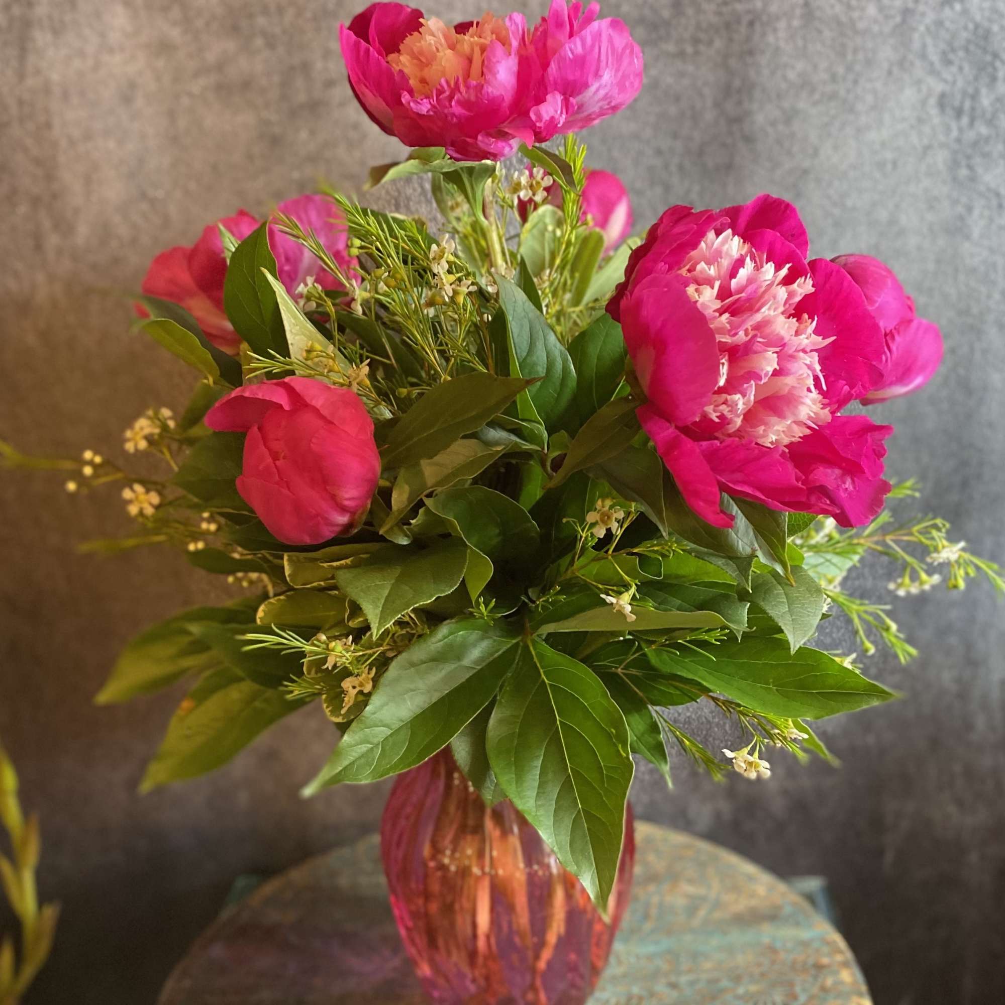 Pink peony bouquet in a pink glass vase