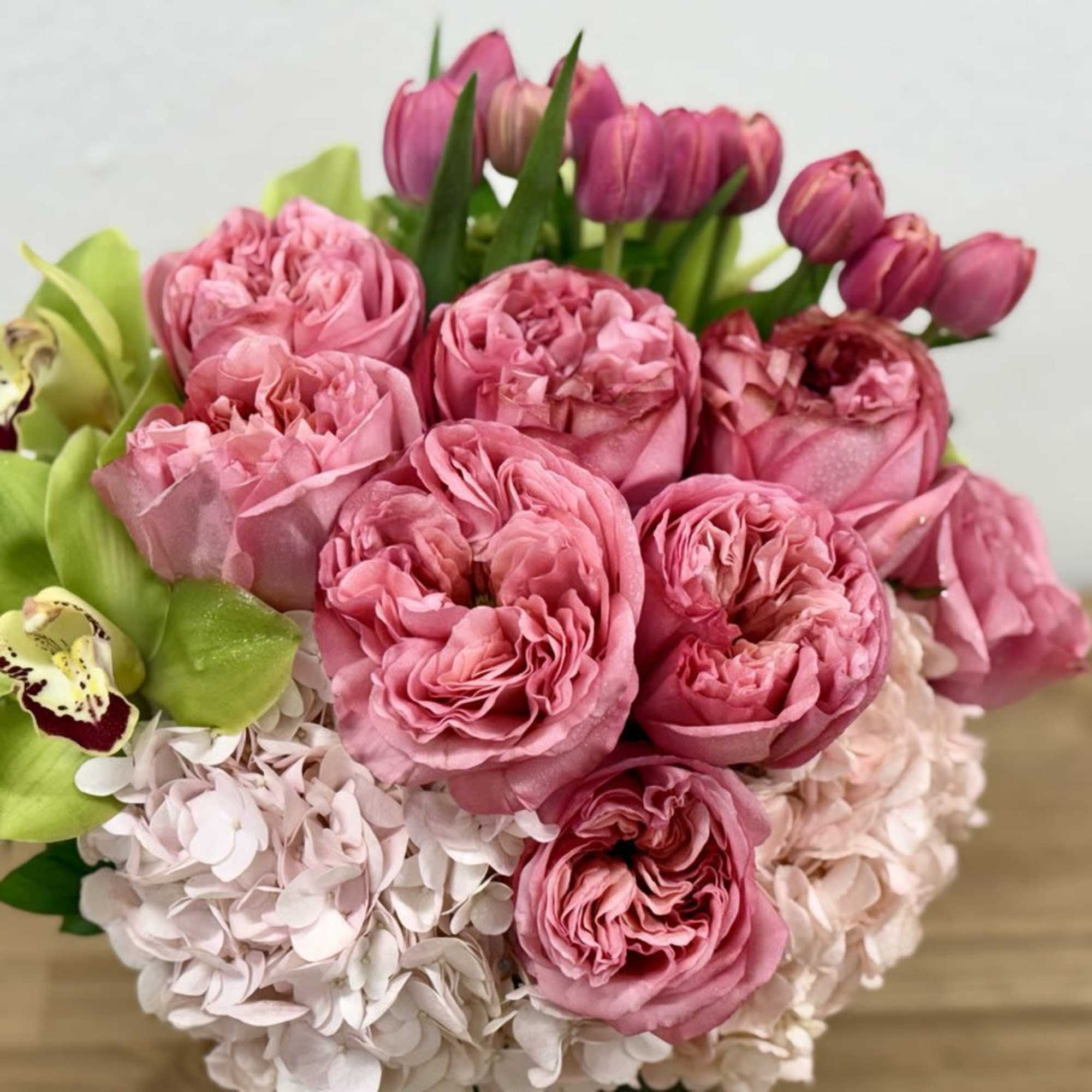 Pink roses and hydrangeas with green orchids in a bouquet