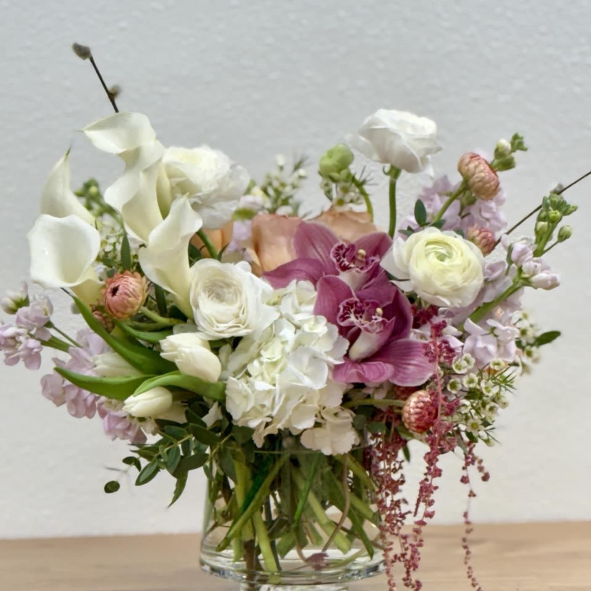 Mixed bouquet of white and pink flowers in a clear glass vase