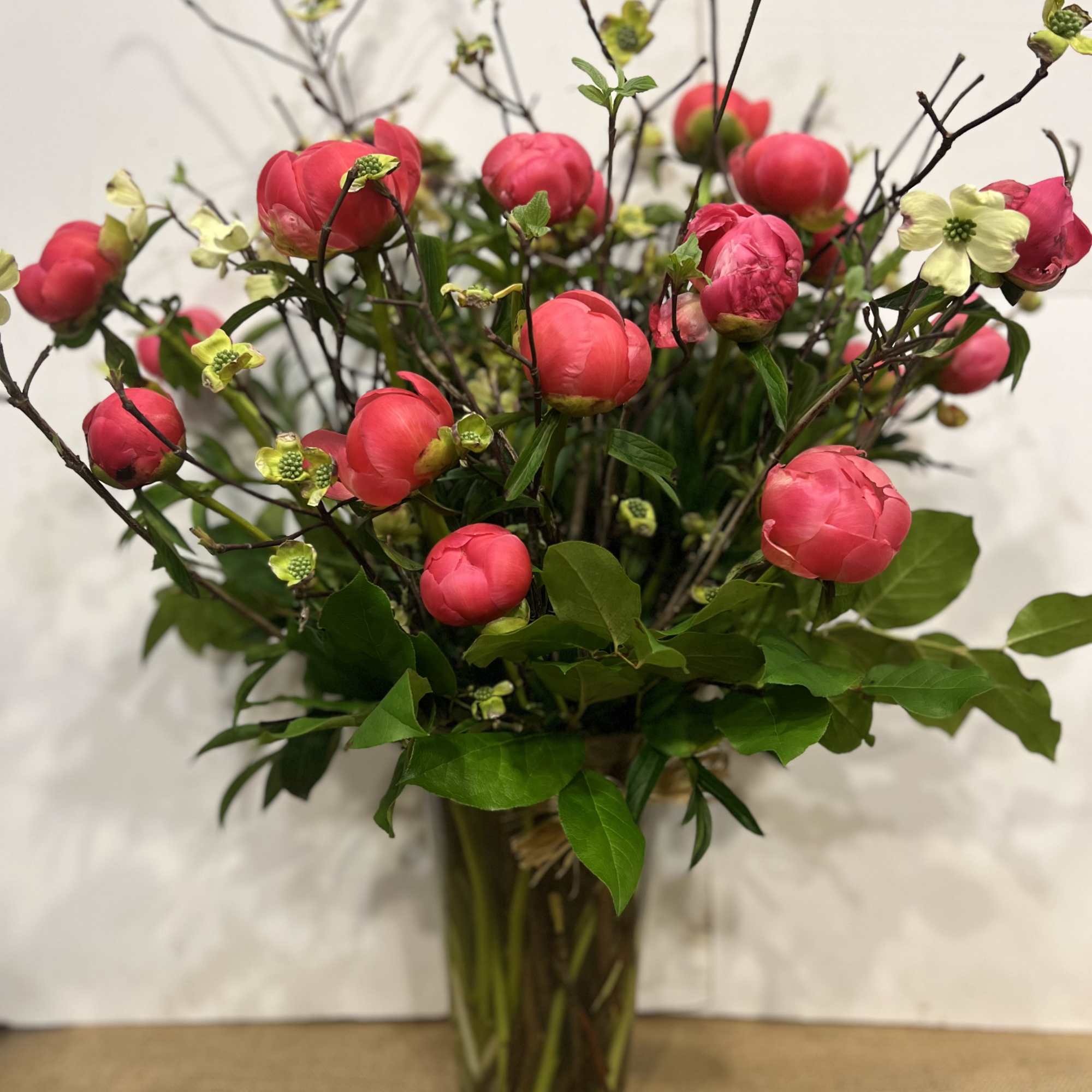Medium high floral arrangement compose of an assortment of Coral charm peonies