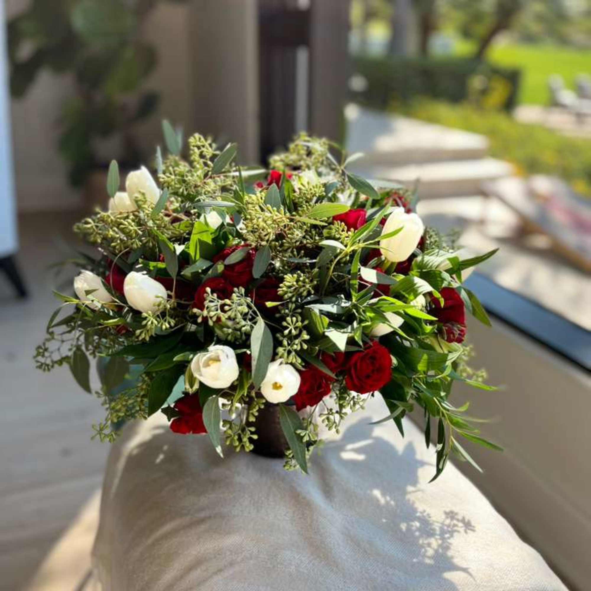 Bouquet of red and white flowers in a dark vase