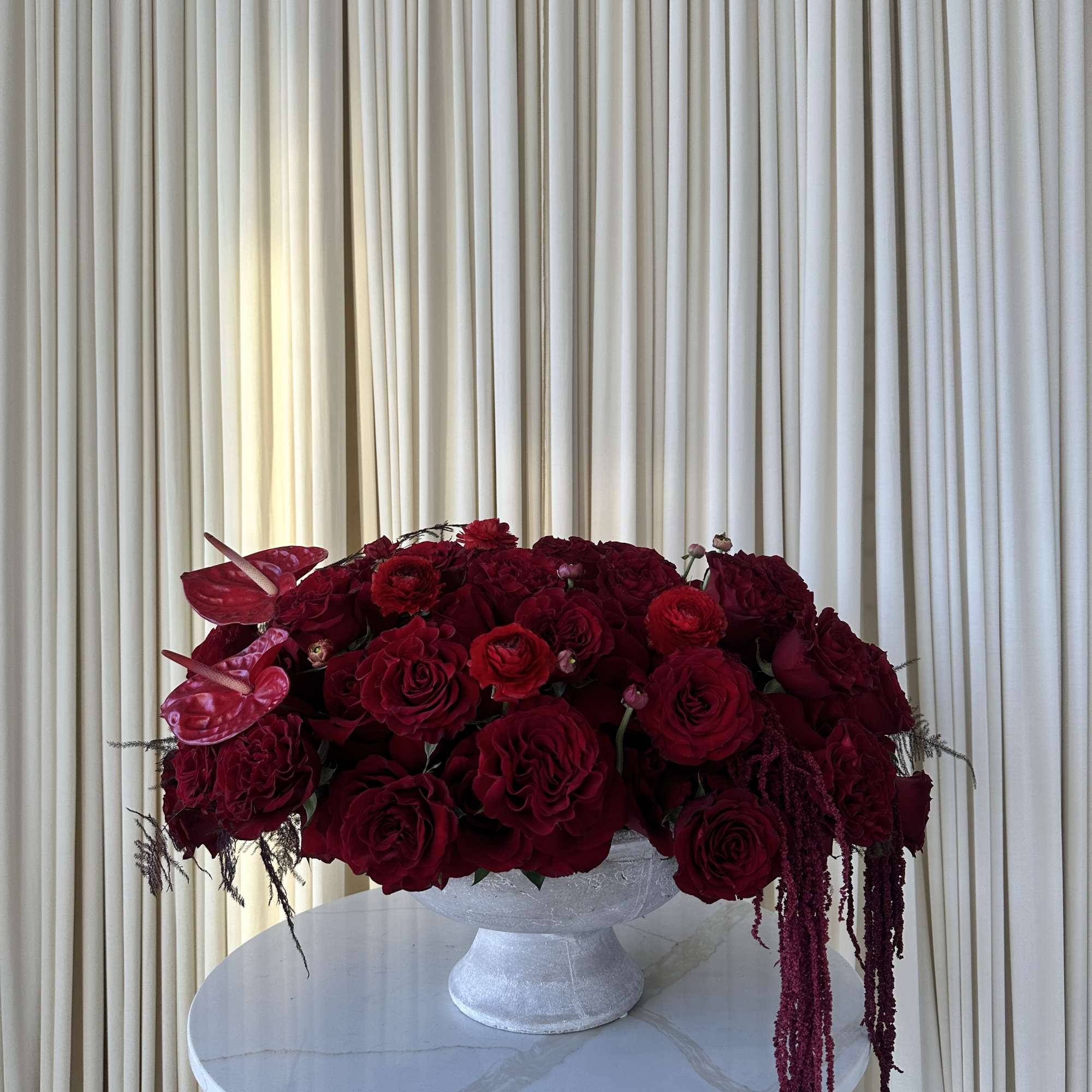 A lush mound of deep red roses and ranunculus creates the first